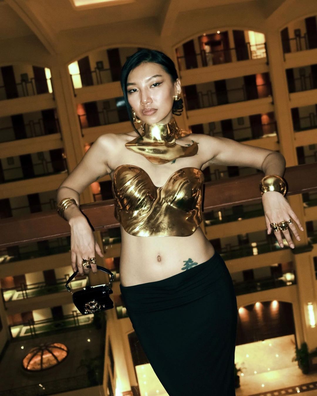 Instagram creator Ikvison Jamang wearing a gold corset top and jewellery with a black skirt 