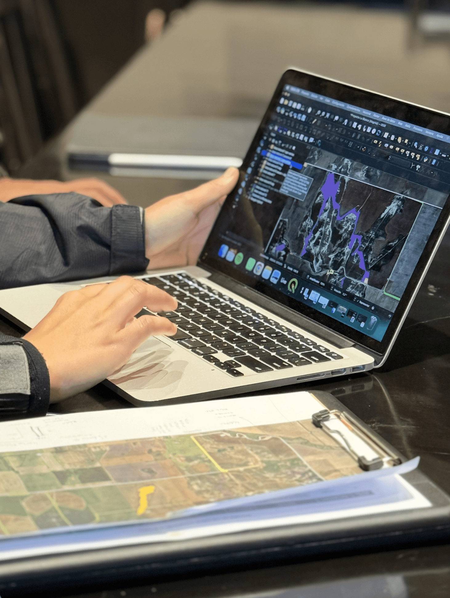 Close-up of a dark green leaf showing its textured surface and central vein against a muted background.