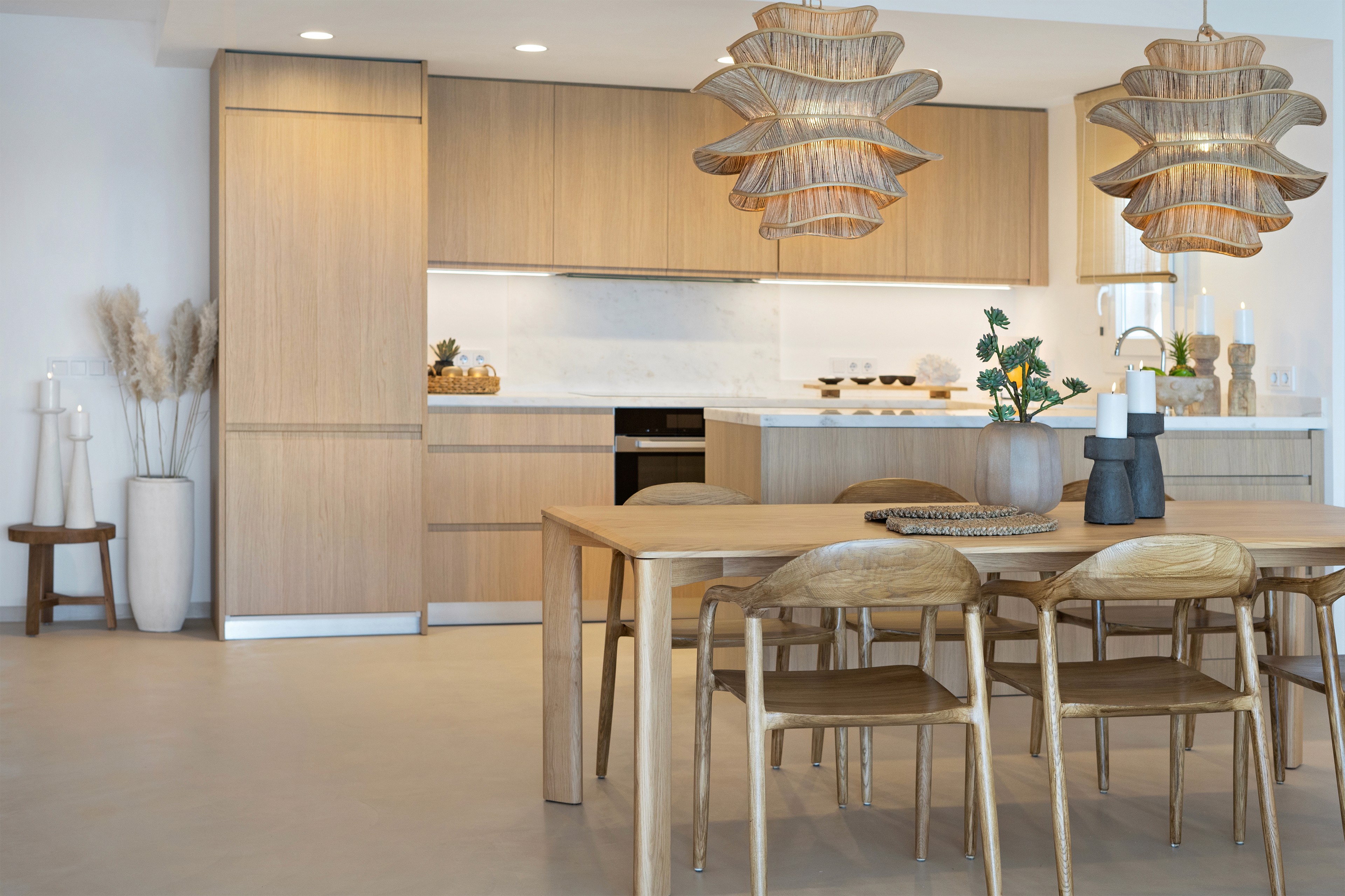 Essbereich des Penthouse in Ses Covetes mit Holztisch, offener Küche und modernem, reduziertem Interior Design