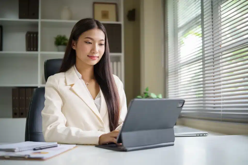Best software for landlords used by professional woman managing properties on tablet in modern office.