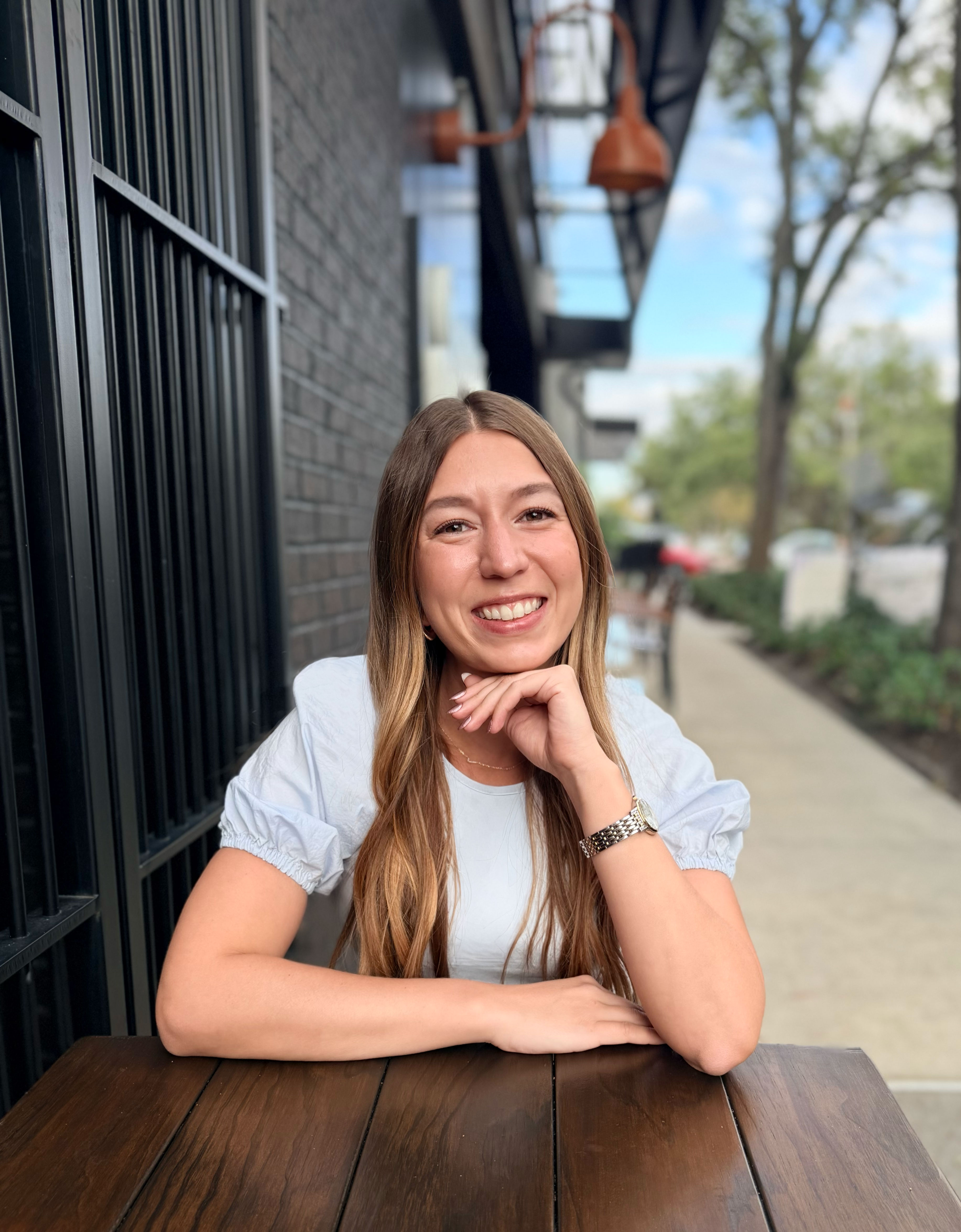 Julie Morris, Tampa Bay Realtor®, smiling at an outdoor table in Hyde Park