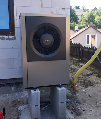 Venkovní jednotka tepelného čerpadla během instalace u novostavby.