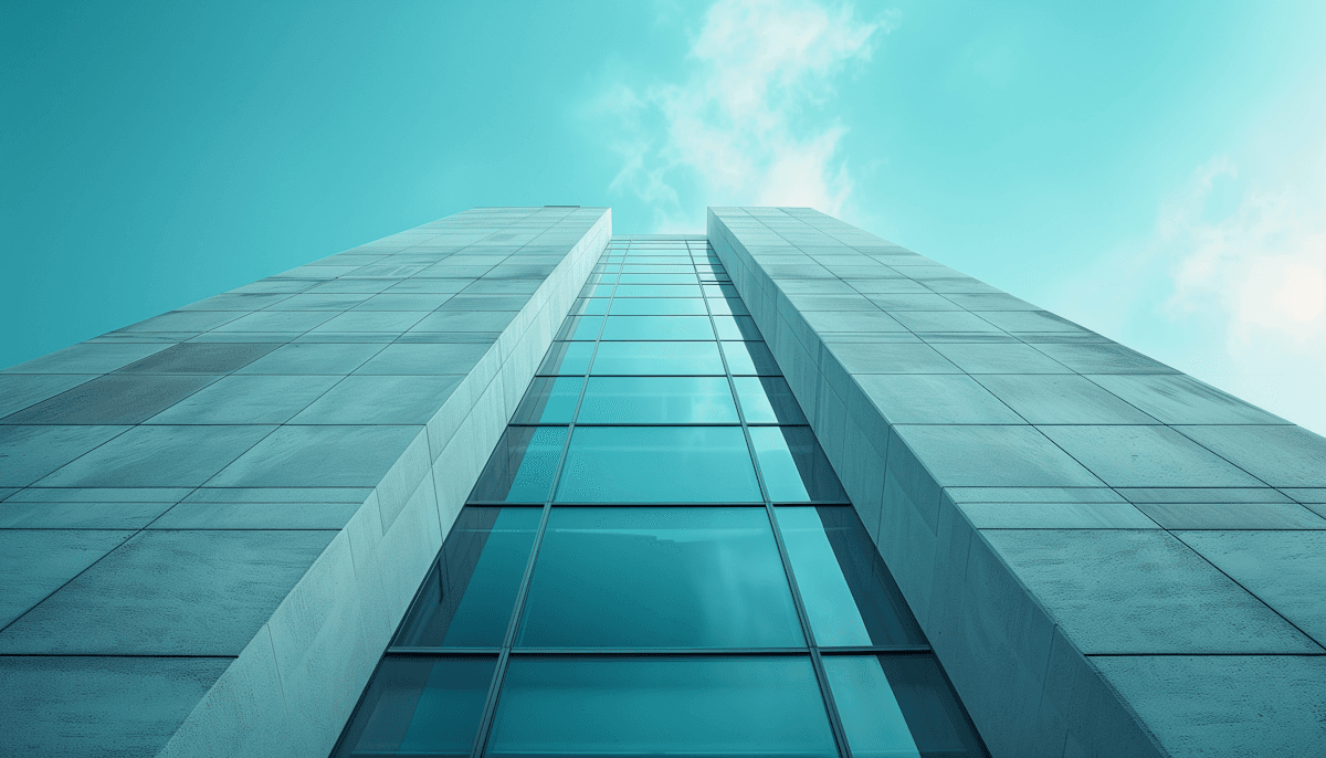 Looking up at a tall building with a teal facade.