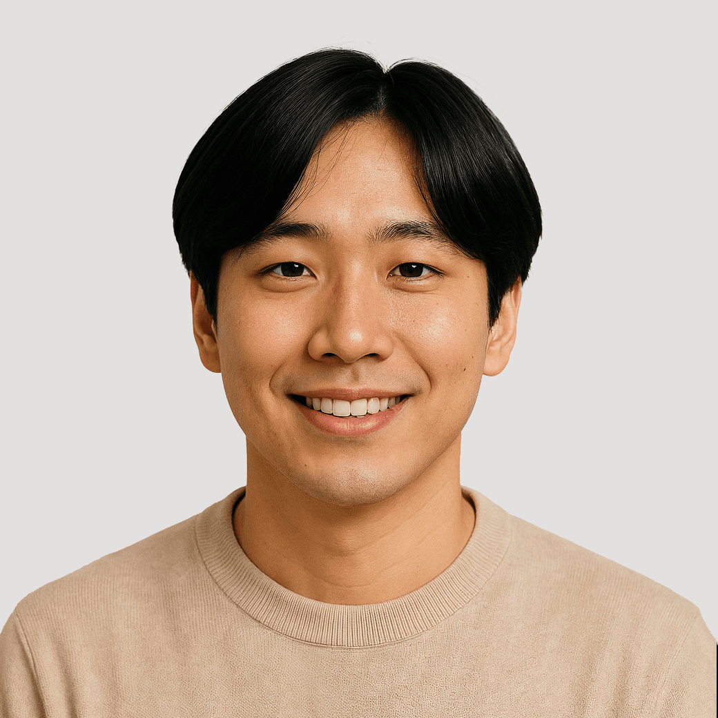 Young Asian man smiling, wearing a beige sweater.