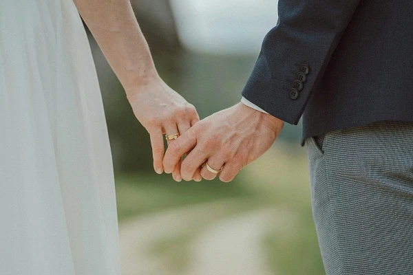 Wedding couple holding hands and showing their rings