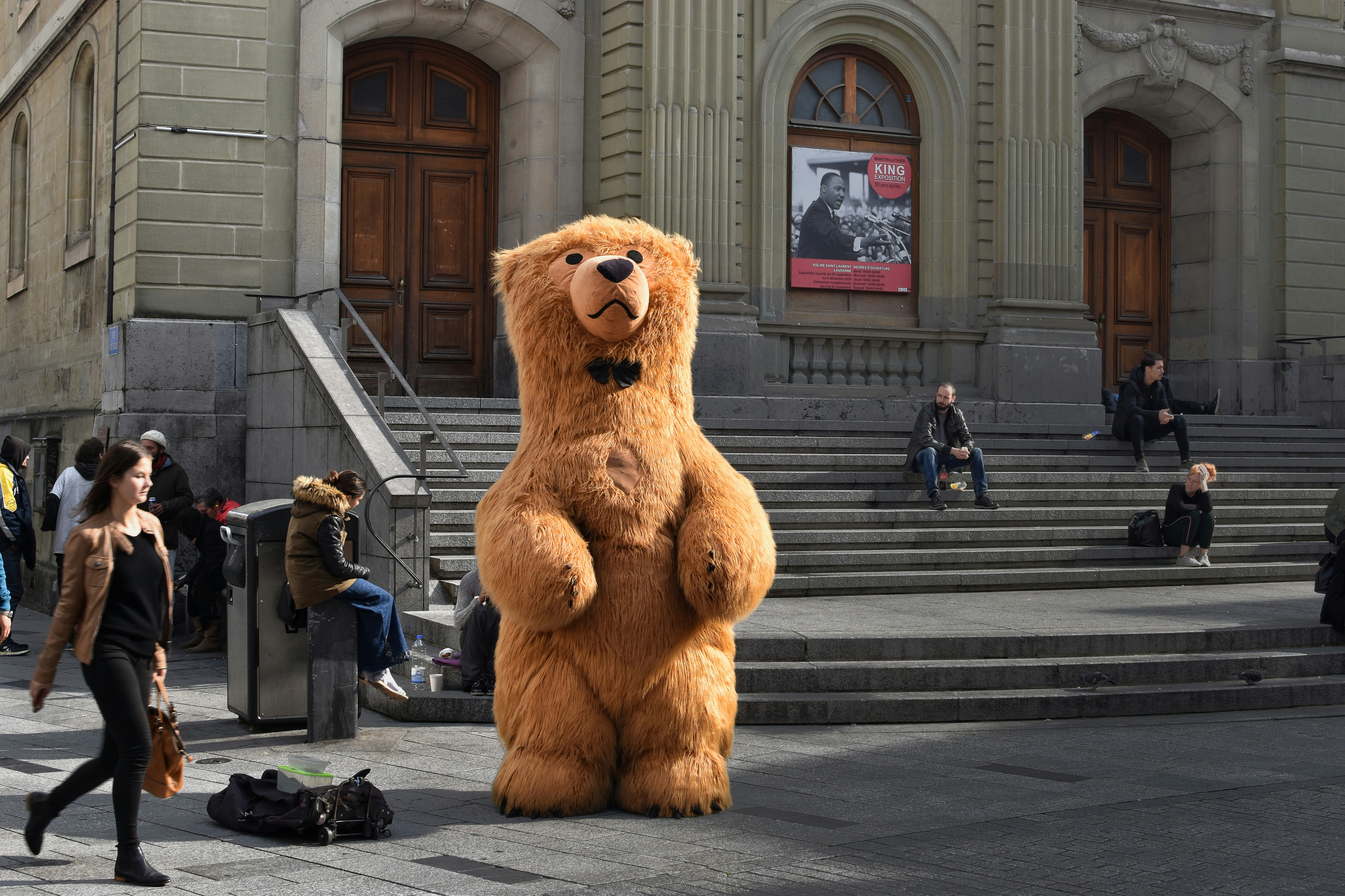 brown bear mascot standing in front of building