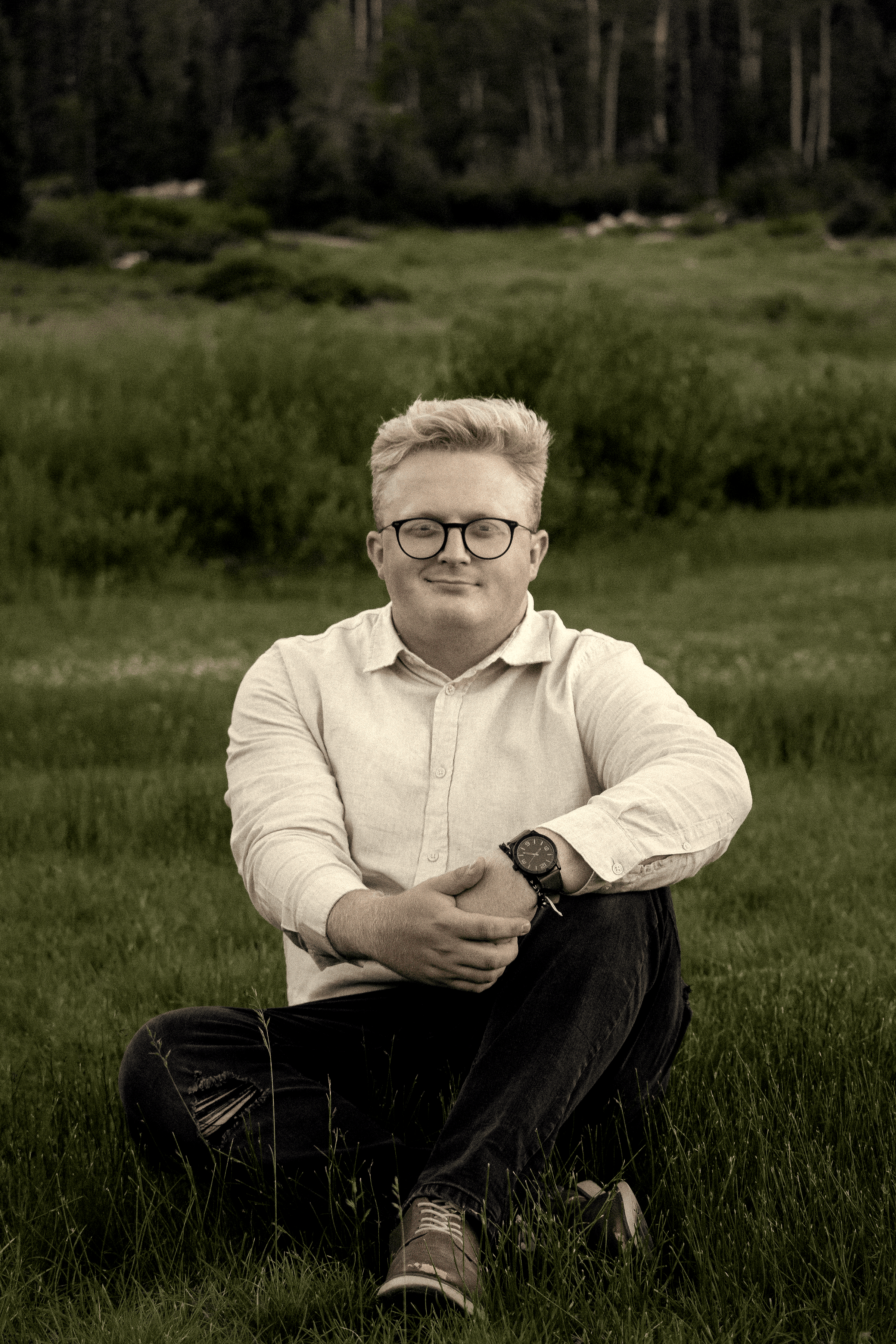 Jackson Tuttle owner of the website sitting in a field looking at the camera