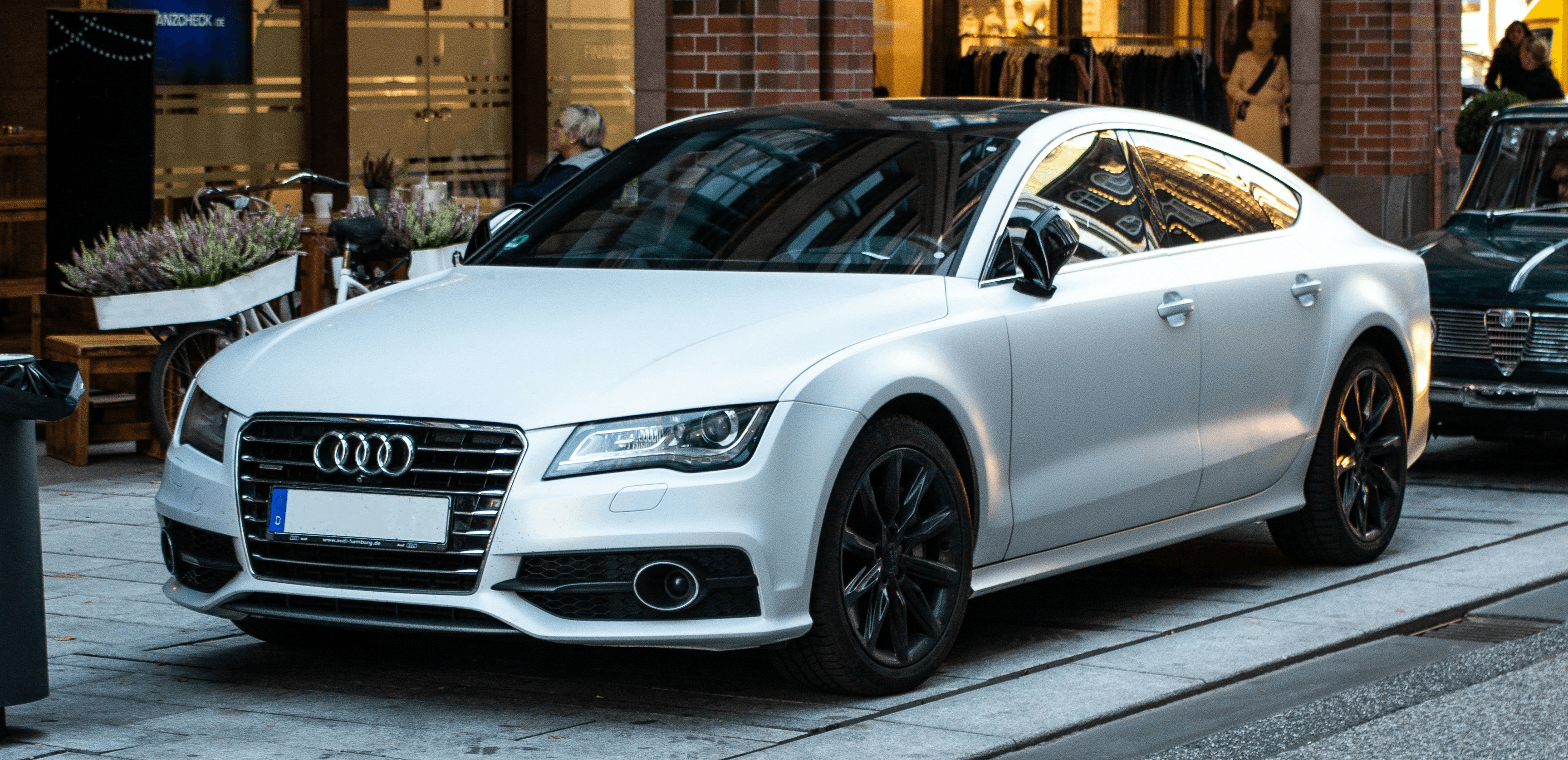 silver Audi sedan parked on street beside restore