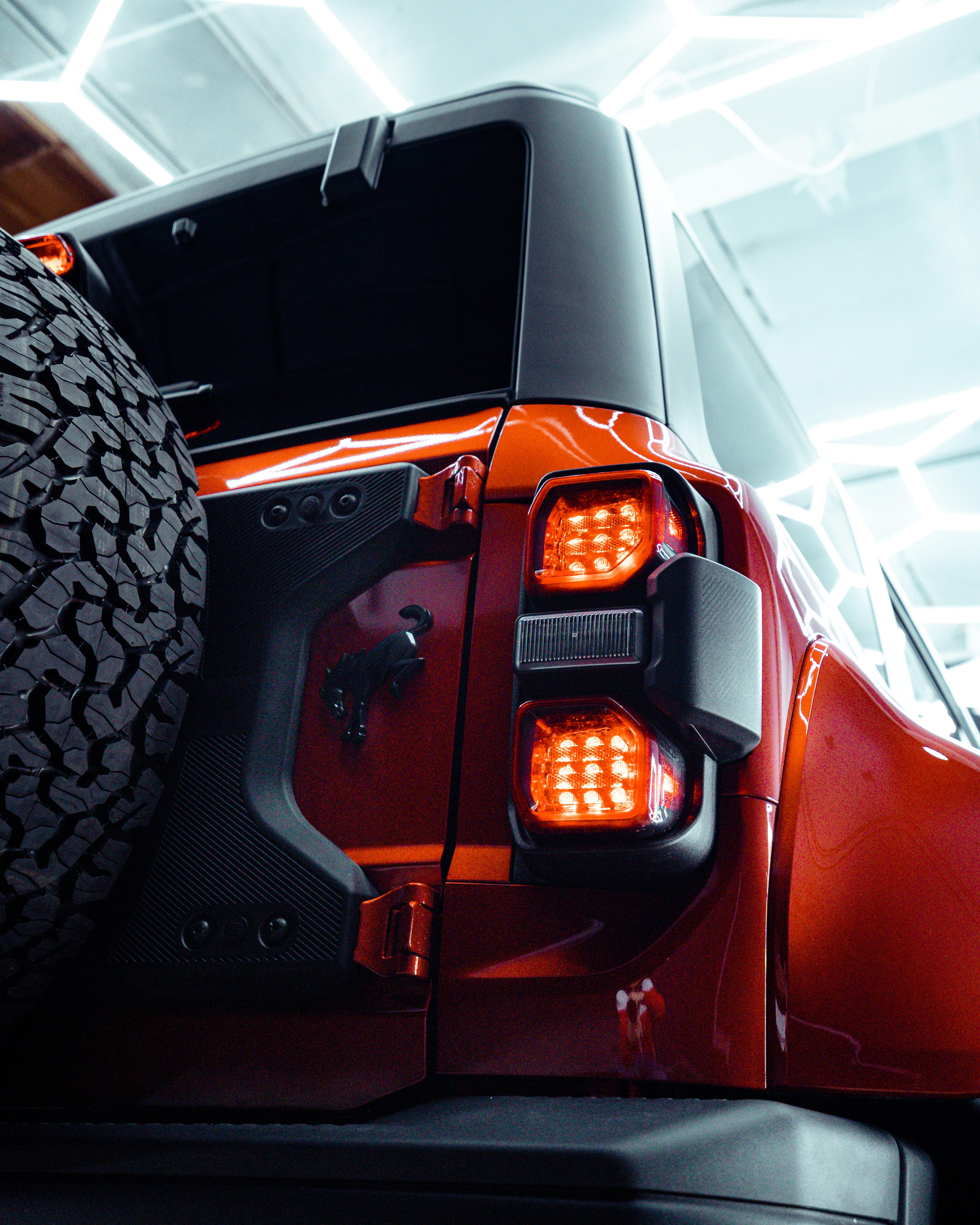 Rear taillight and spare tire detail on an orange Ford Bronco Raptor with Icon Rocklear permanent paint protection, Dragon Auto Milpitas