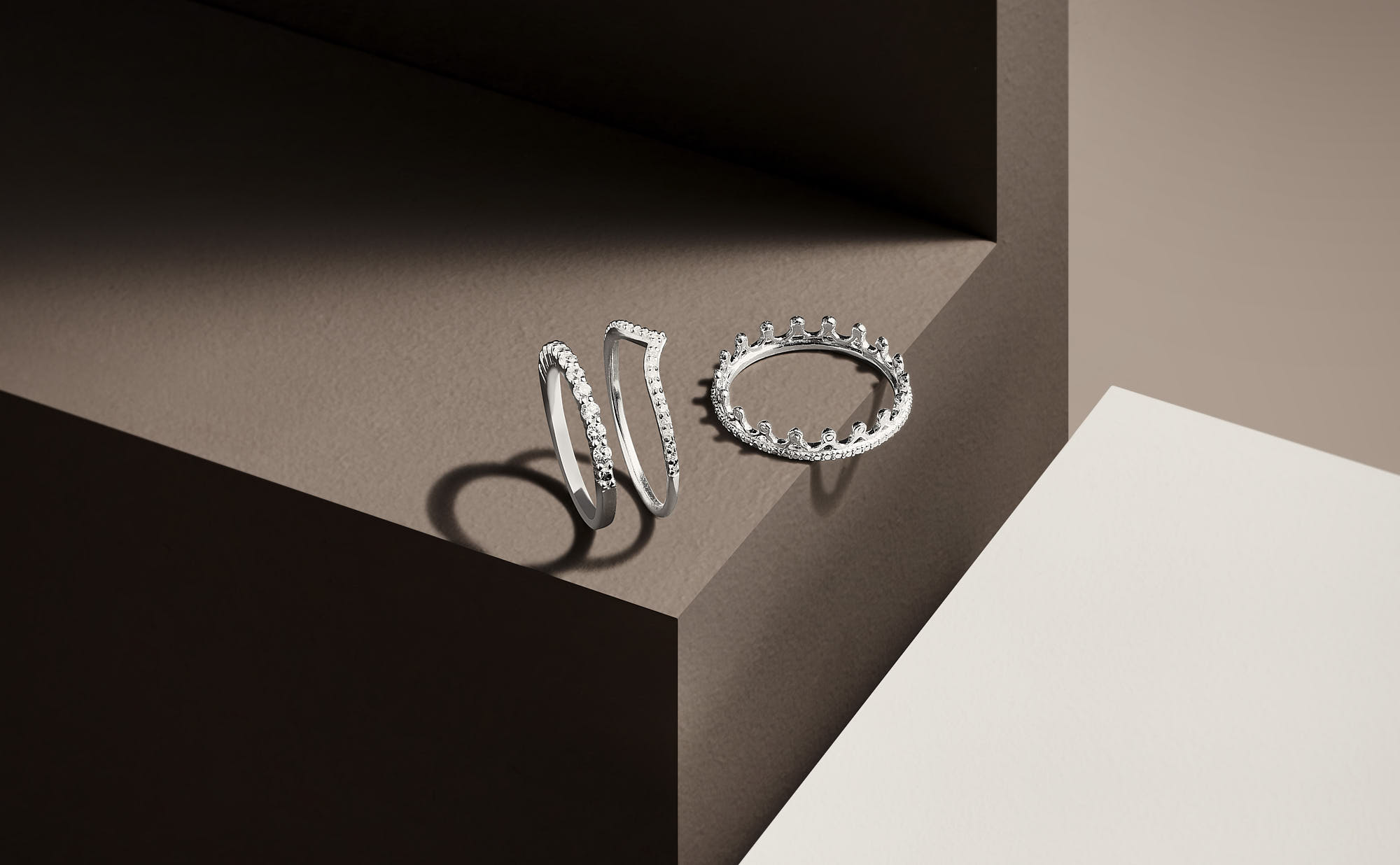 Elegant diamond rings on geometric brown and cream backdrop