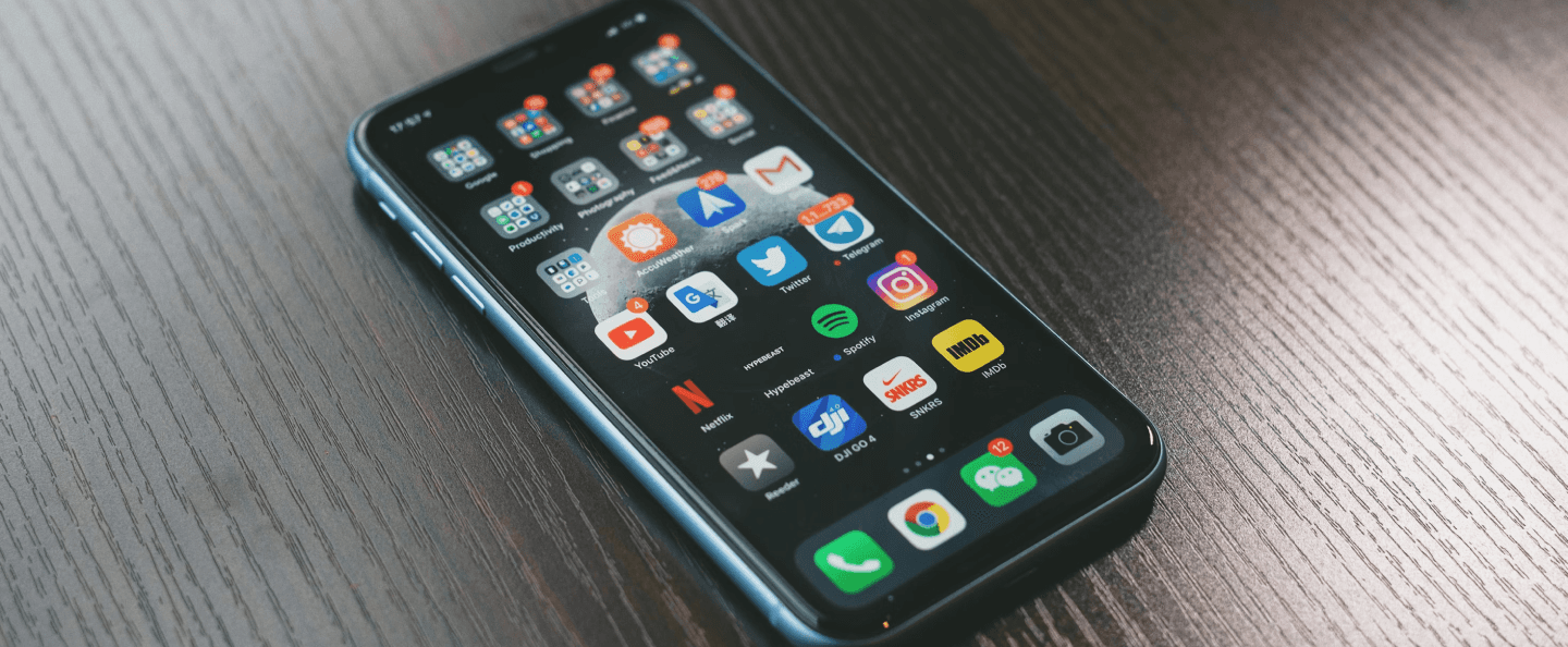 A smartphone screen with app icons for a blog representing Native, Hybrid, and Cross-Platform App Development for Non-Developers.