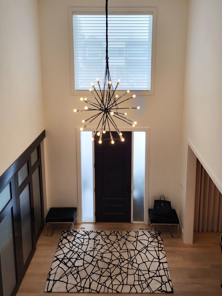 Image of Modern foyer with stylish chandelier, geometric rug, and sleek design by KHD Homes interior design experts.