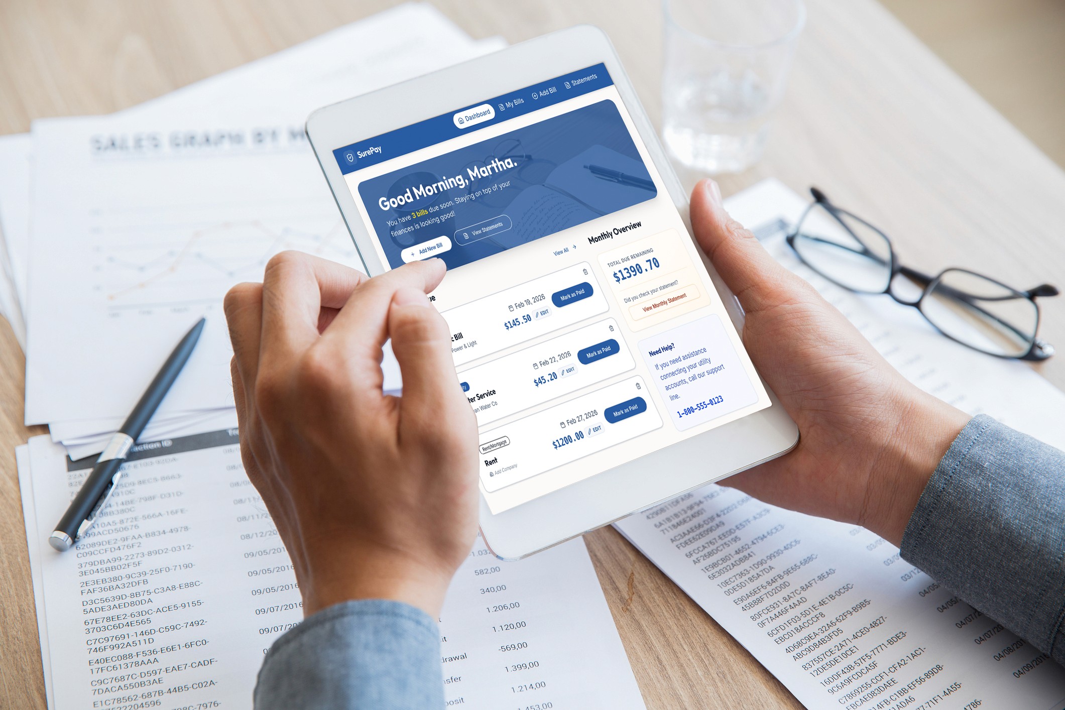 Senior citizen using Surepay on a white tablet at a desk.