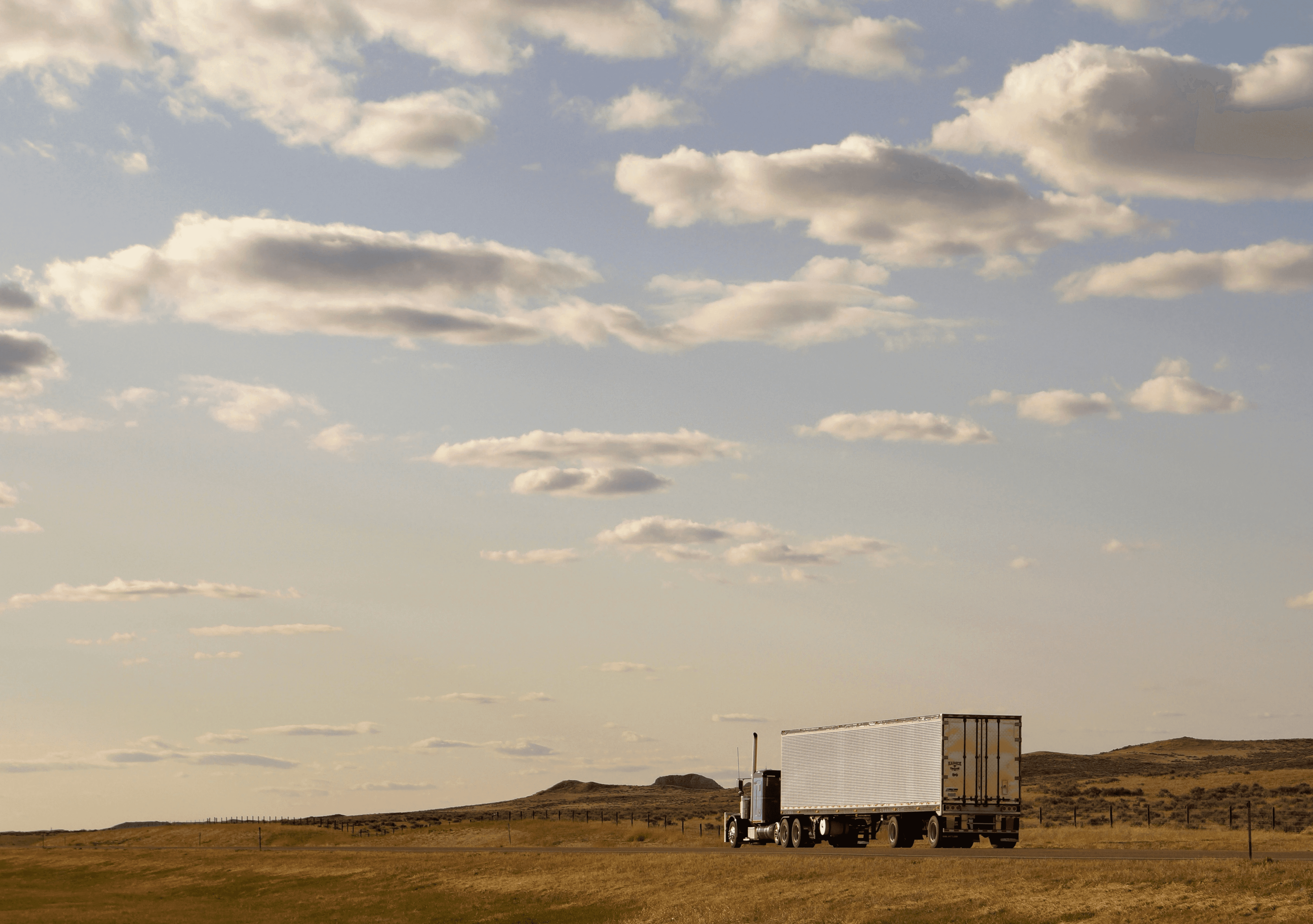 white and blue truck on green grass field under white clouds during daytime