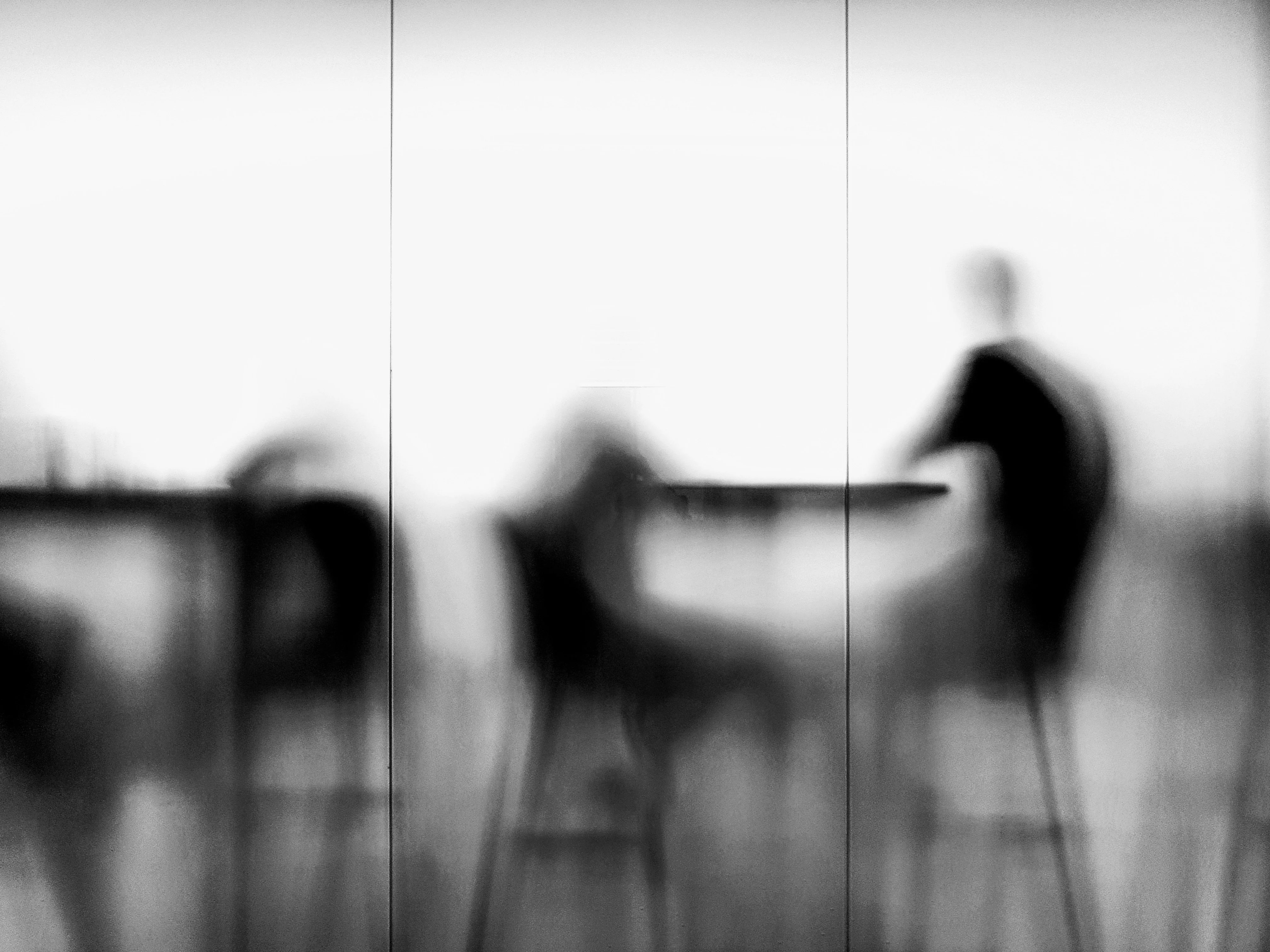 Blurred silhouettes of people meeting at a table