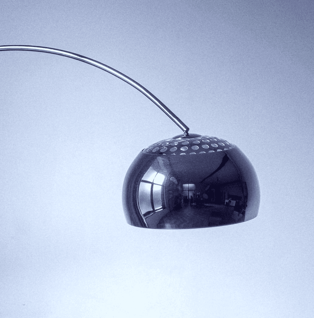 brown wooden framed white padded armchair beside white wall