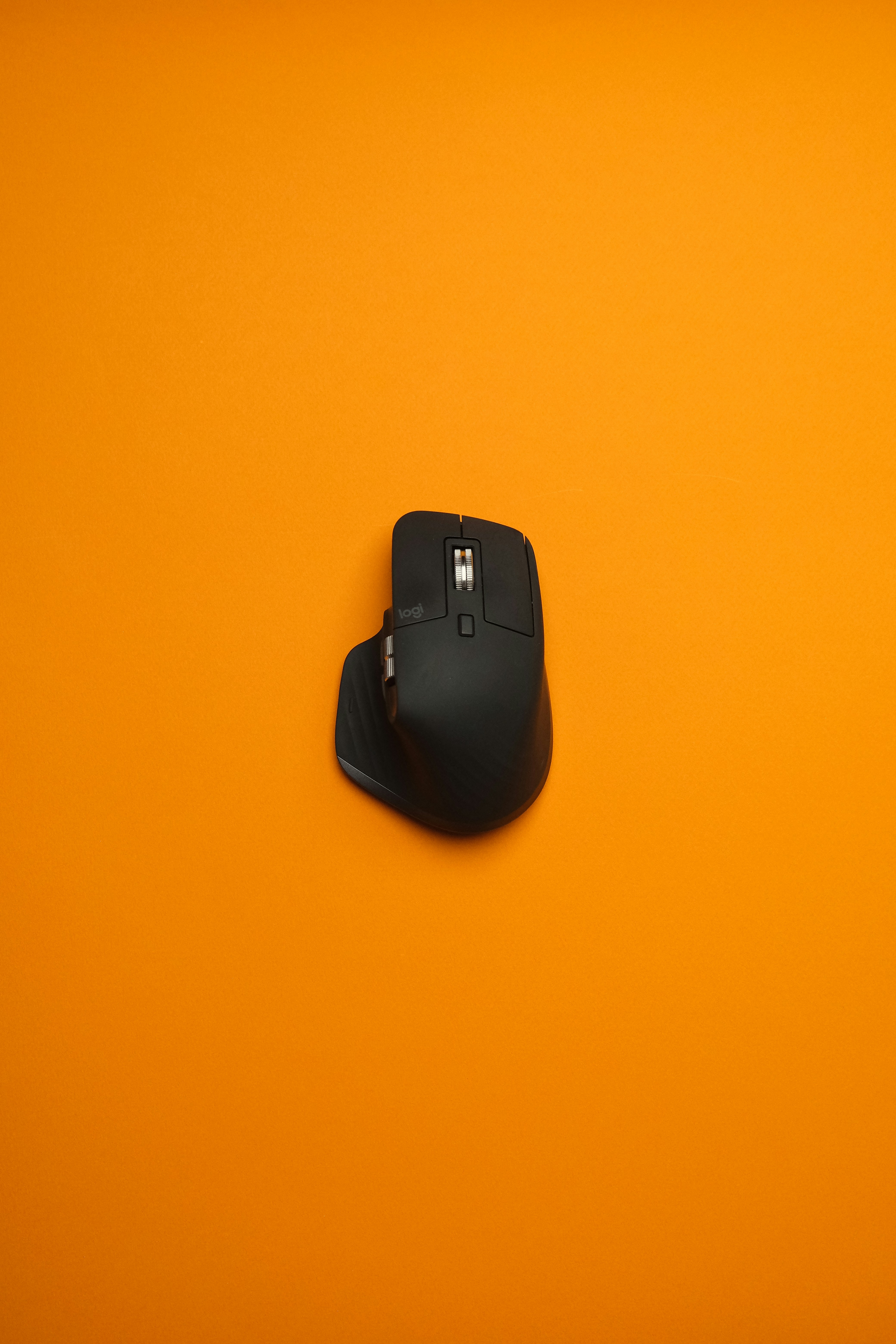 A computer mouse sitting on top of an orange surface