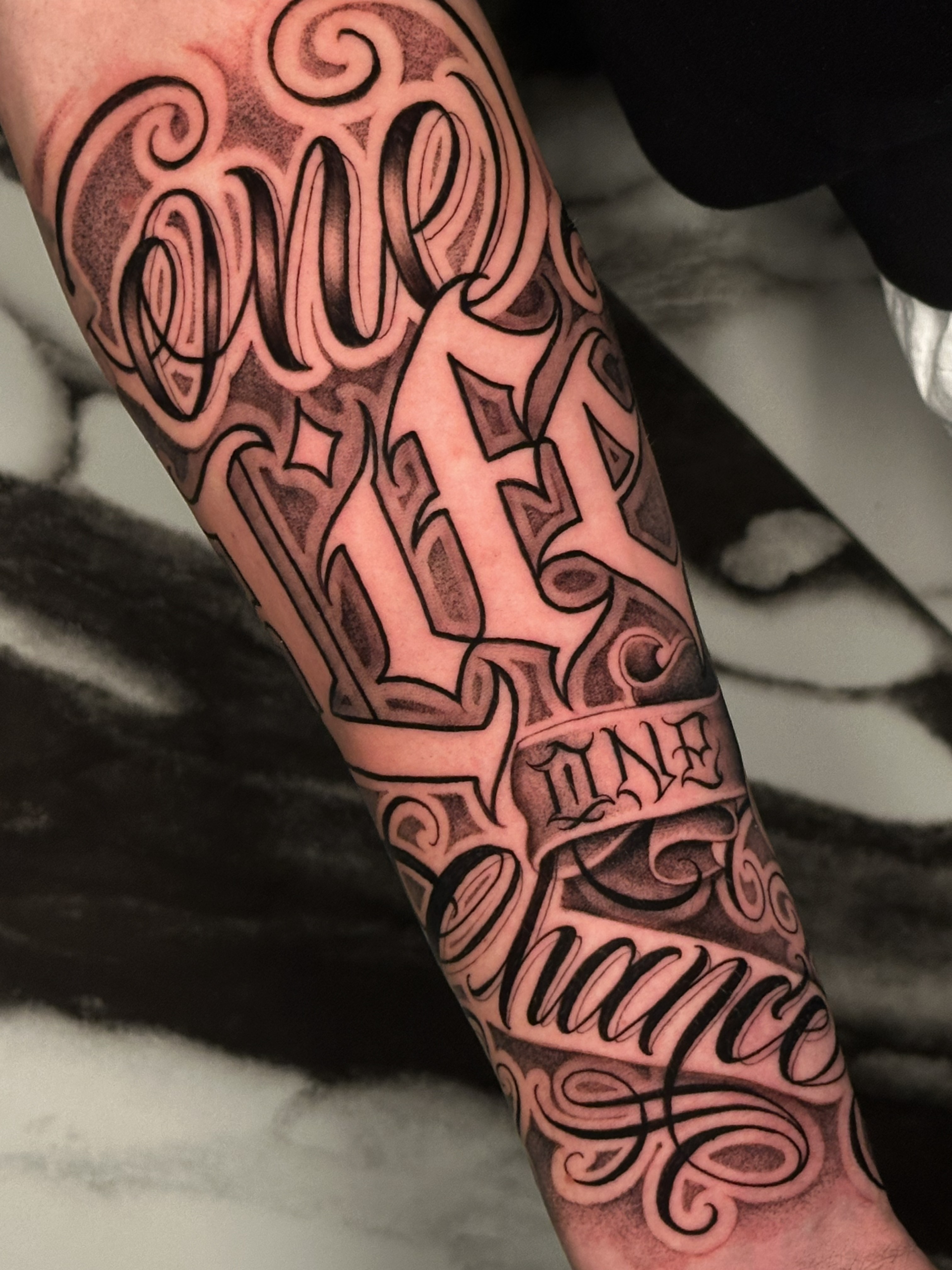 tatuaggio sull'avambraccio in stile chicano