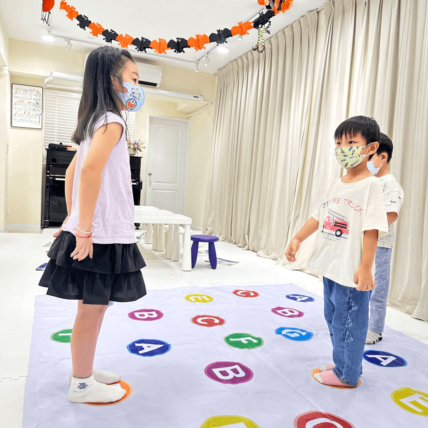 Two people installing or adjusting abstract blue artworks on a gallery wall 