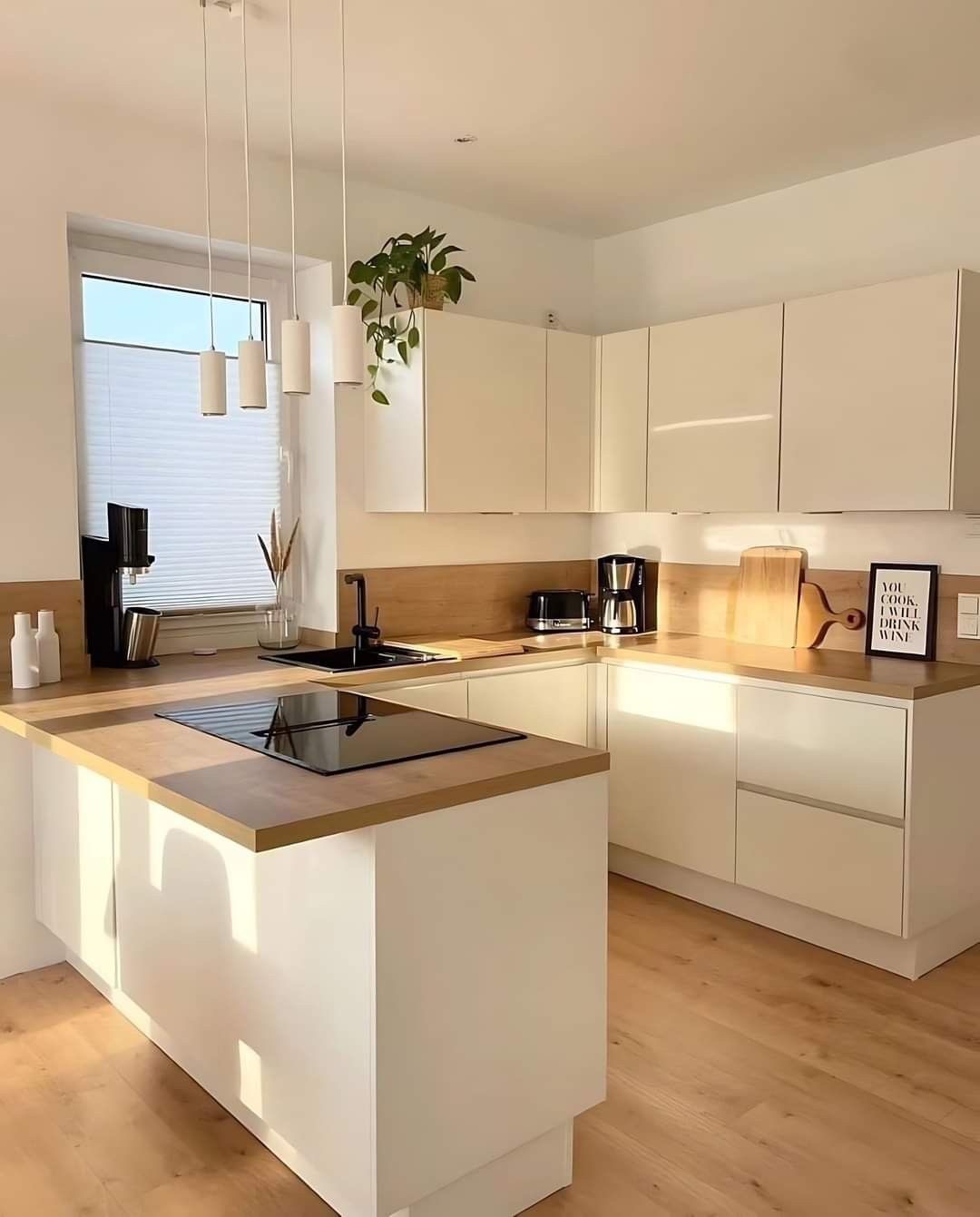 Modern kitchen with a wooden dining table, white chairs, and a hanging light fixture above.
