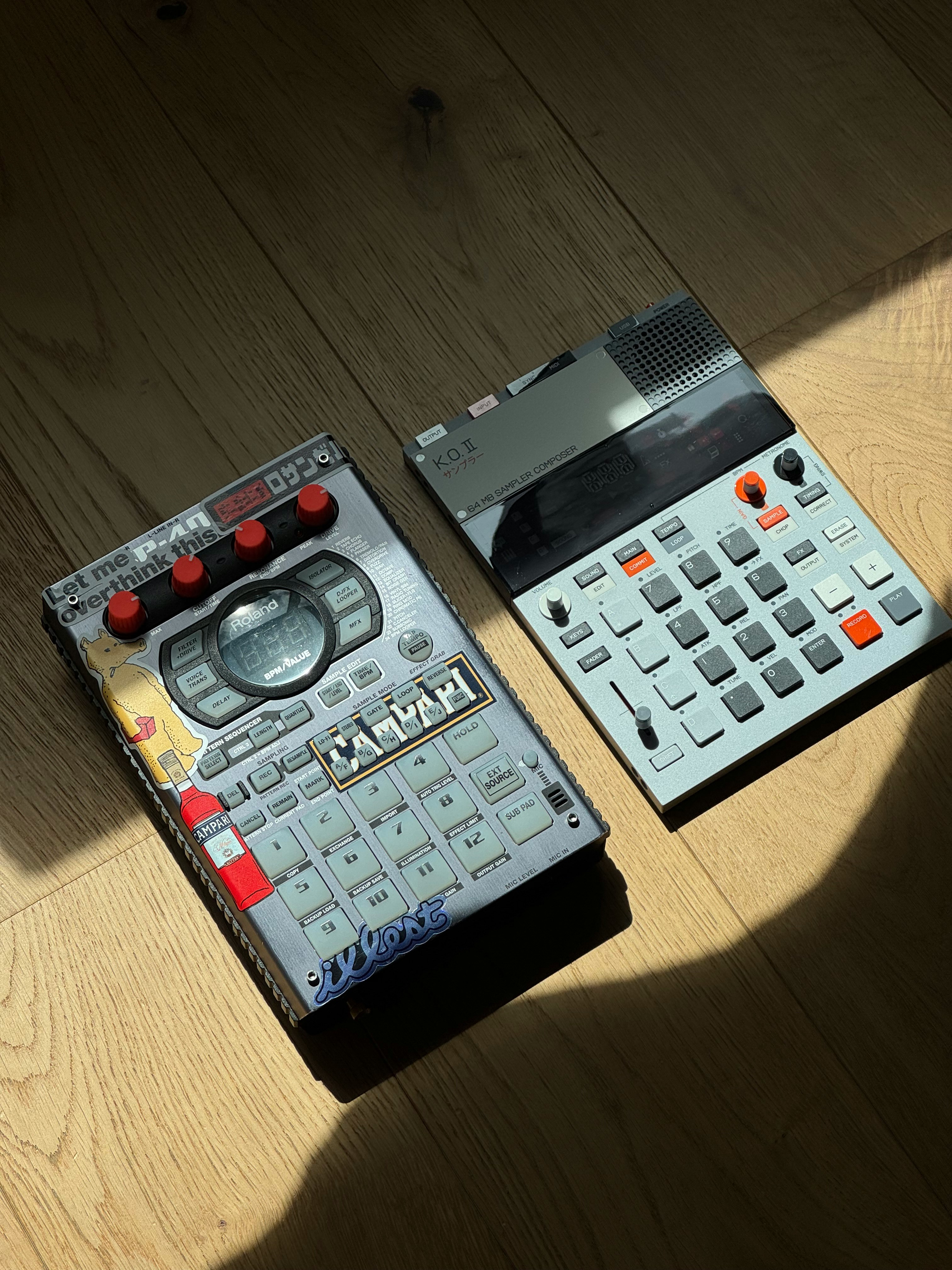 Two electronic music production devices on wooden floor.