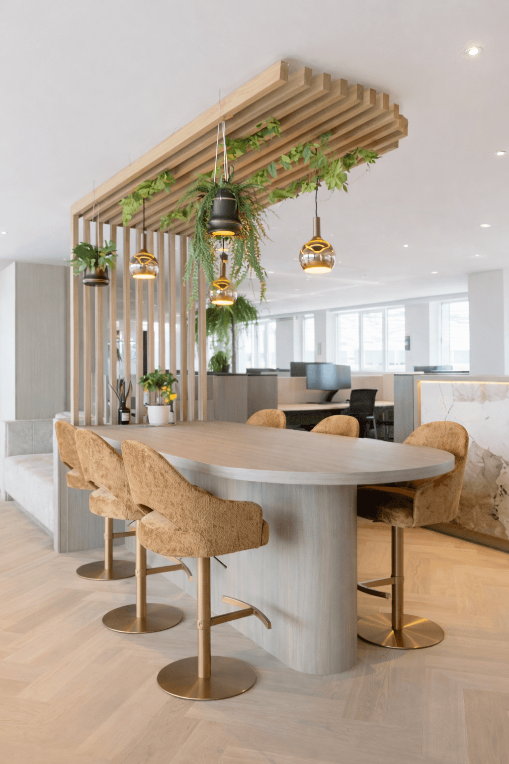 Conception d'un espace de travail professionnel à Bordeaux – table ovale, claustra bois au plafond, végétaux suspendus, optimisation des circulations et de l'image