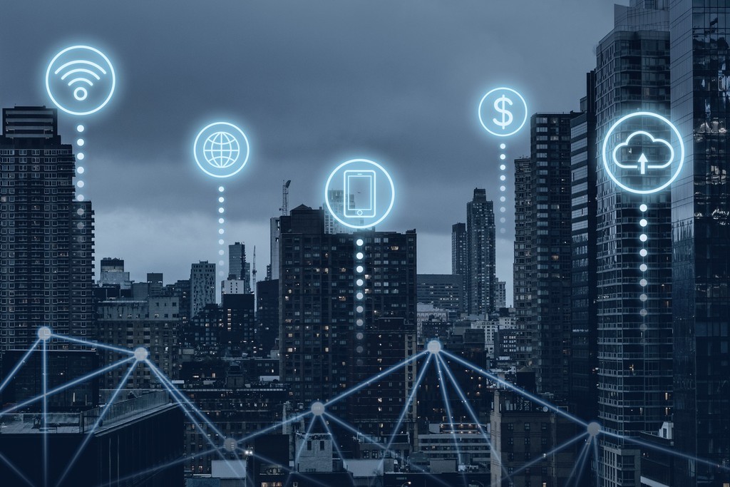 Skyline urbano noturno com ícones digitais de Wi-Fi, internet, dispositivo móvel, pagamento digital e cloud computing interconectados, representando infraestrutura de smart city e conectividade urbana - FindUP - Rede de computadores