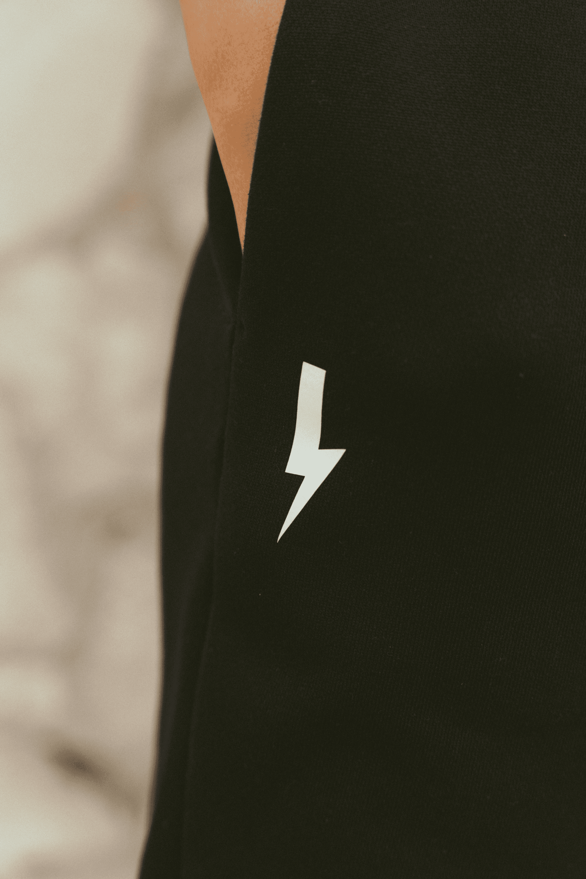 Close-up-of-a-black-garment-with-a-white-lighting-bolt-sign-on-the-side-The-background-is-blured
