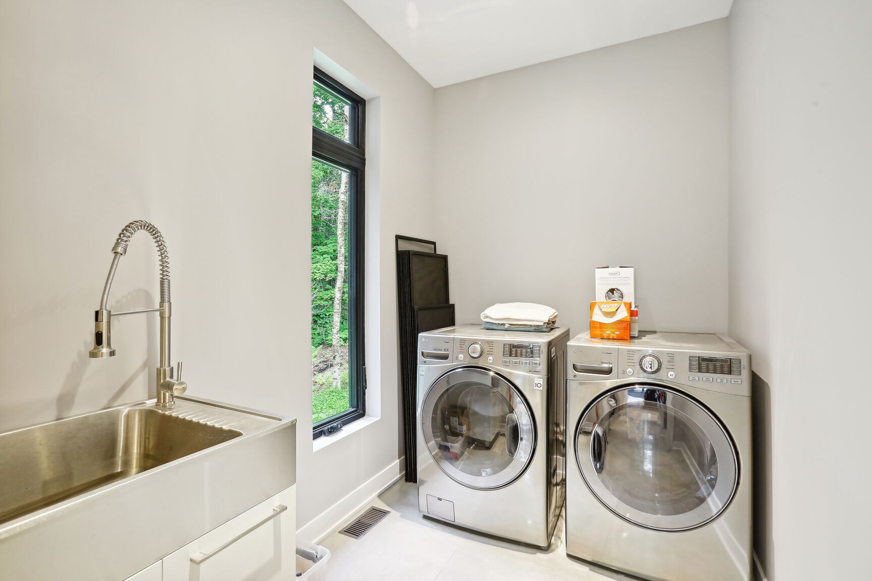 Buanderie au RDC avec évier et rangements.