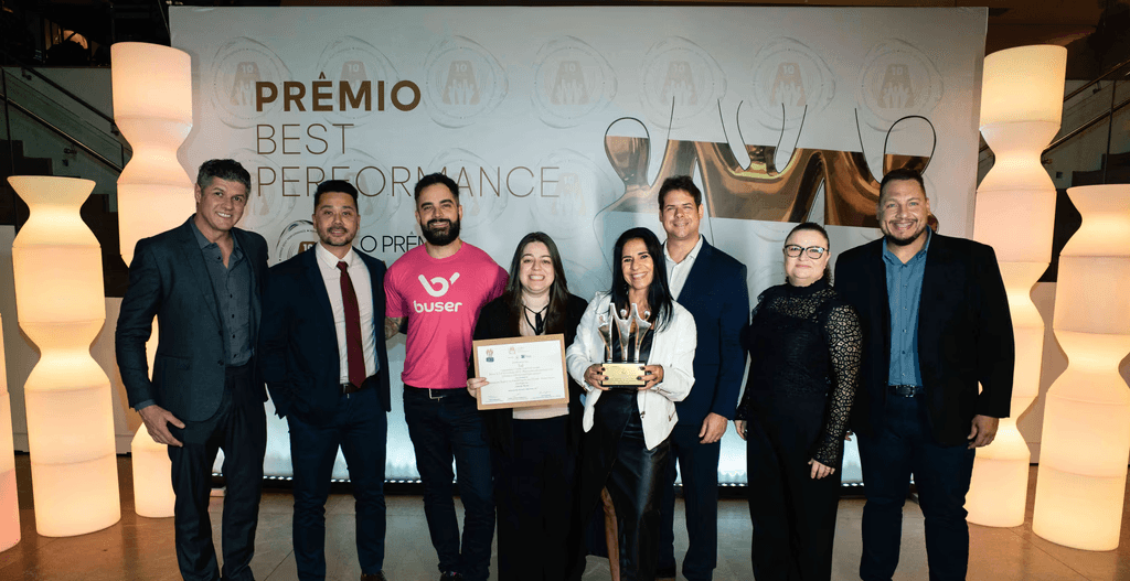 Executivos da Tel posando com troféu ouro e certificado no palco do Prêmio Best Performance 2025