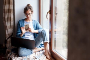 Young woman browsing her phone at home