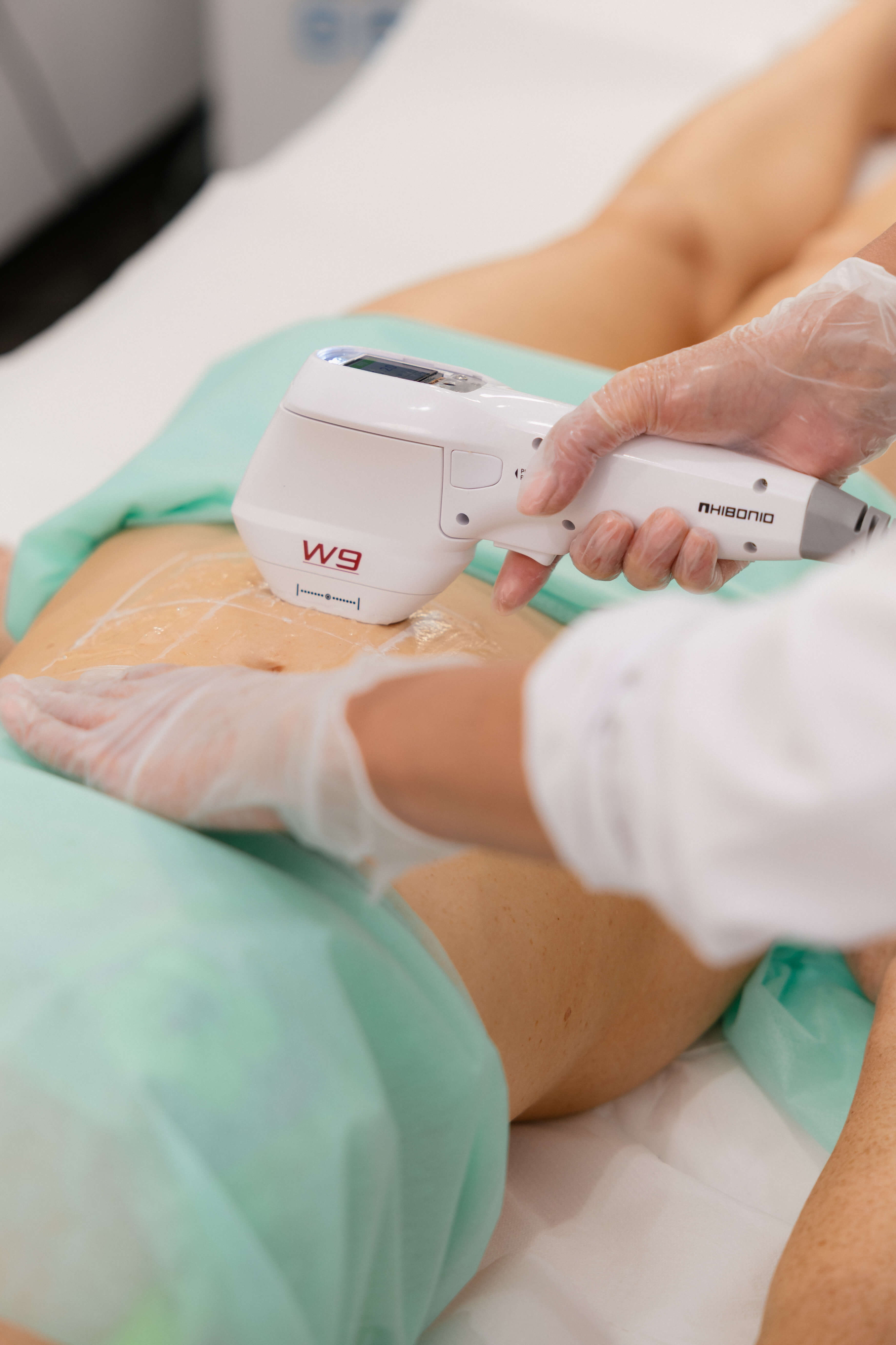 Close-up of a professional aesthetic device being used for a body treatment.