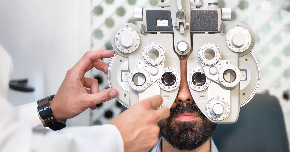 En mann får sjekket synet hos en optiker.