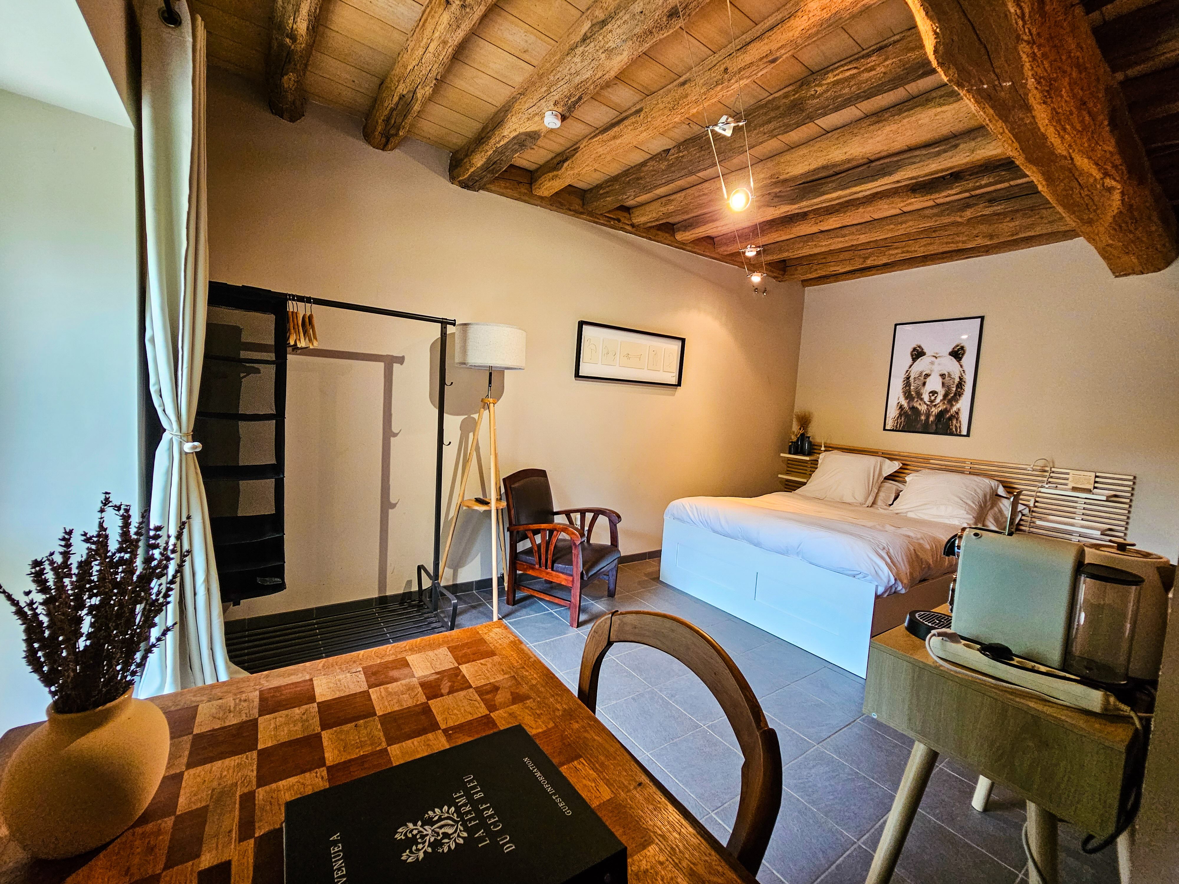 Chambre avec poutres apparentes et lit.