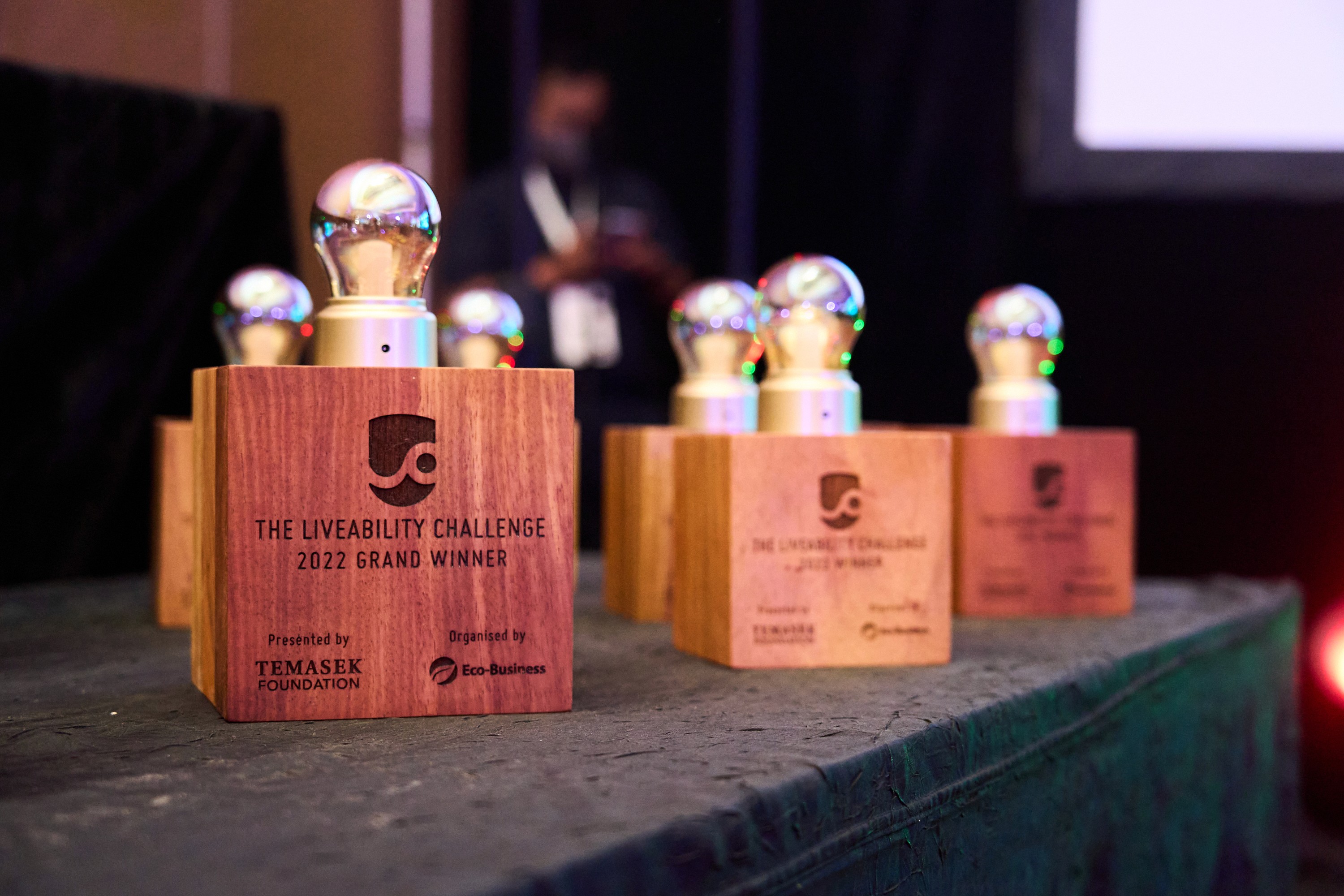 Display of trophy-like figures on a table with a blurred background, possibly at an event or ceremony.