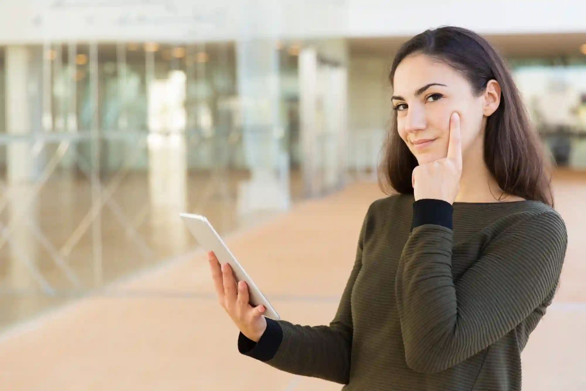 Woman with a tablet pointing to her eye, indicating focus or using visual data for an analysis.