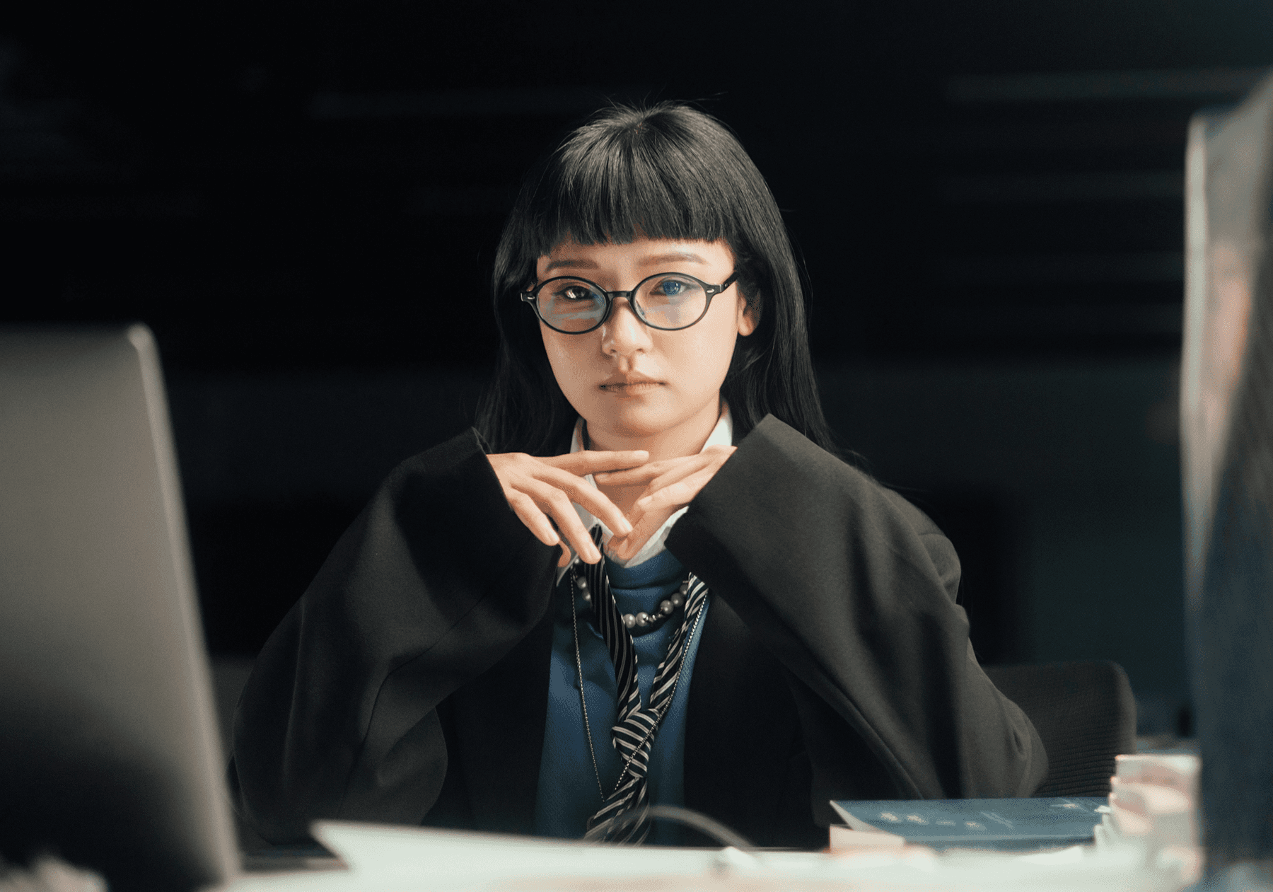 Scholar with dark hair and glasses.