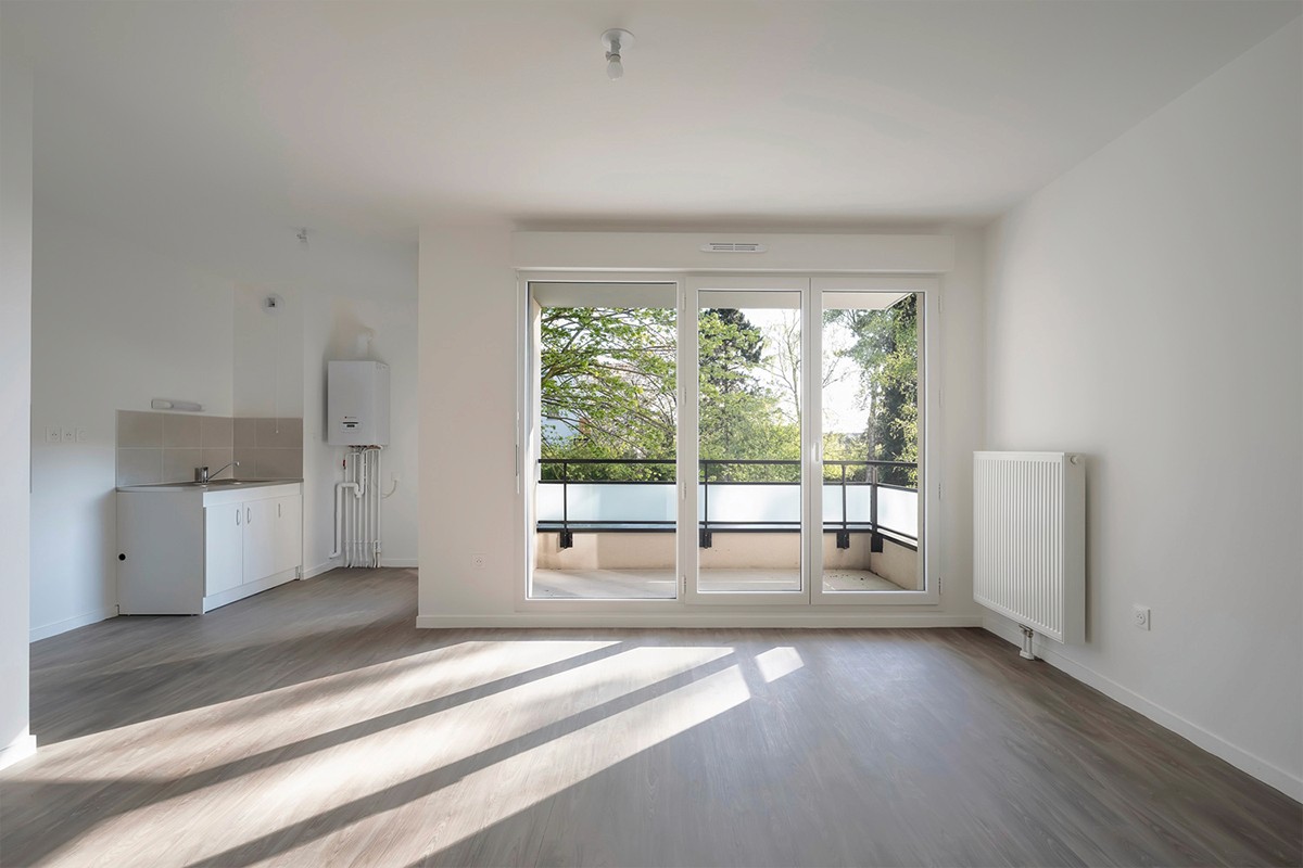 Salon-cuisine vide lumineux avec balcon à Lille — photographie immobilière Nord | Anteale | Yann Manac’h