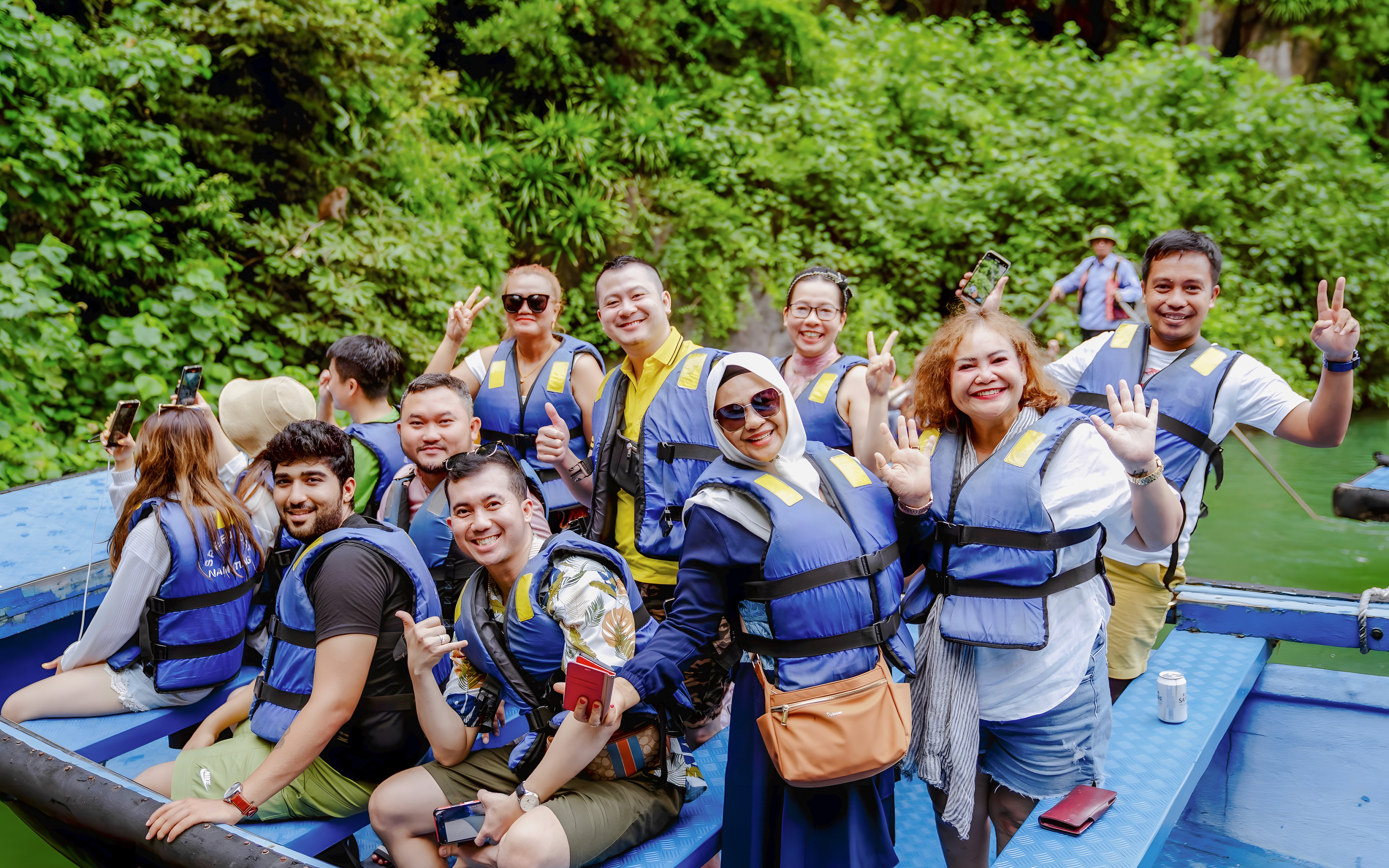 游览团穿着救生衣乘船游览越南下龙湾的石灰岩岩溶地貌。