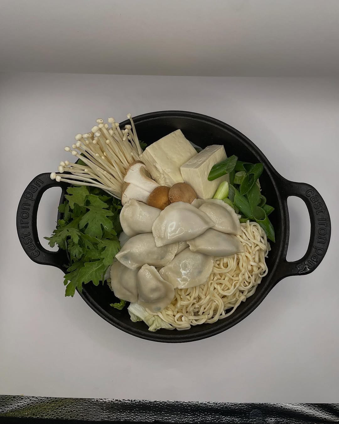Freshly baked Margherita pizza with melted cheese, tomato sauce, and basil leaves, held by a person’s hand.