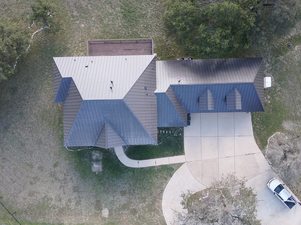 Medium bronze McElroy standing seam metal hip roof with dormers, offering a sleek and modern look with added charm and functionality.