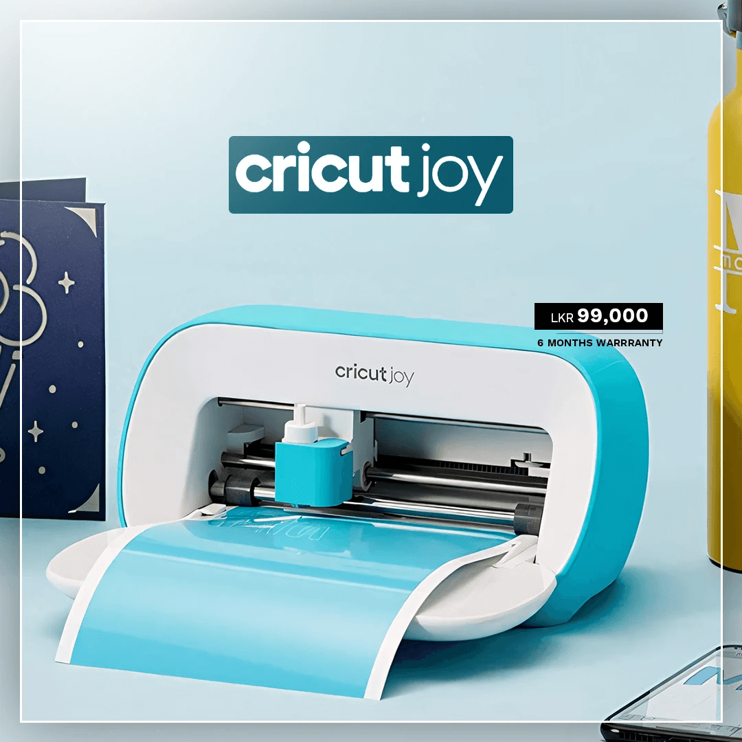 The image features a Cricut Joy at the center of a promotional setup, showcasing its compact design with a piece of blue material being cut, surrounded by a yellow water bottle and a greeting card, with a price tag of LKR 99,000 and a six-month warranty label.
