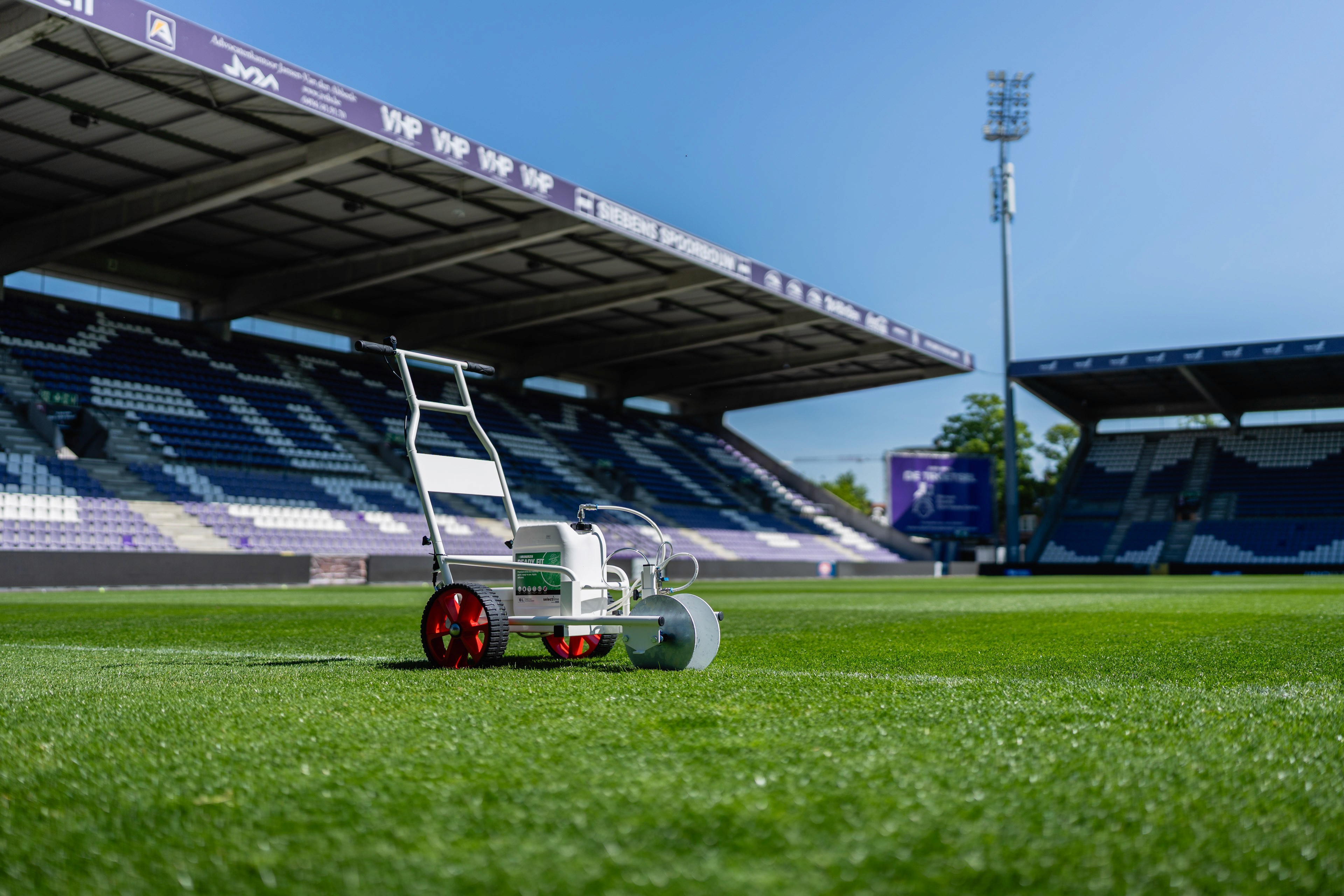 Selectline veldmarkeringsrobot op het kunstgras van een leeg voetbalstadion.