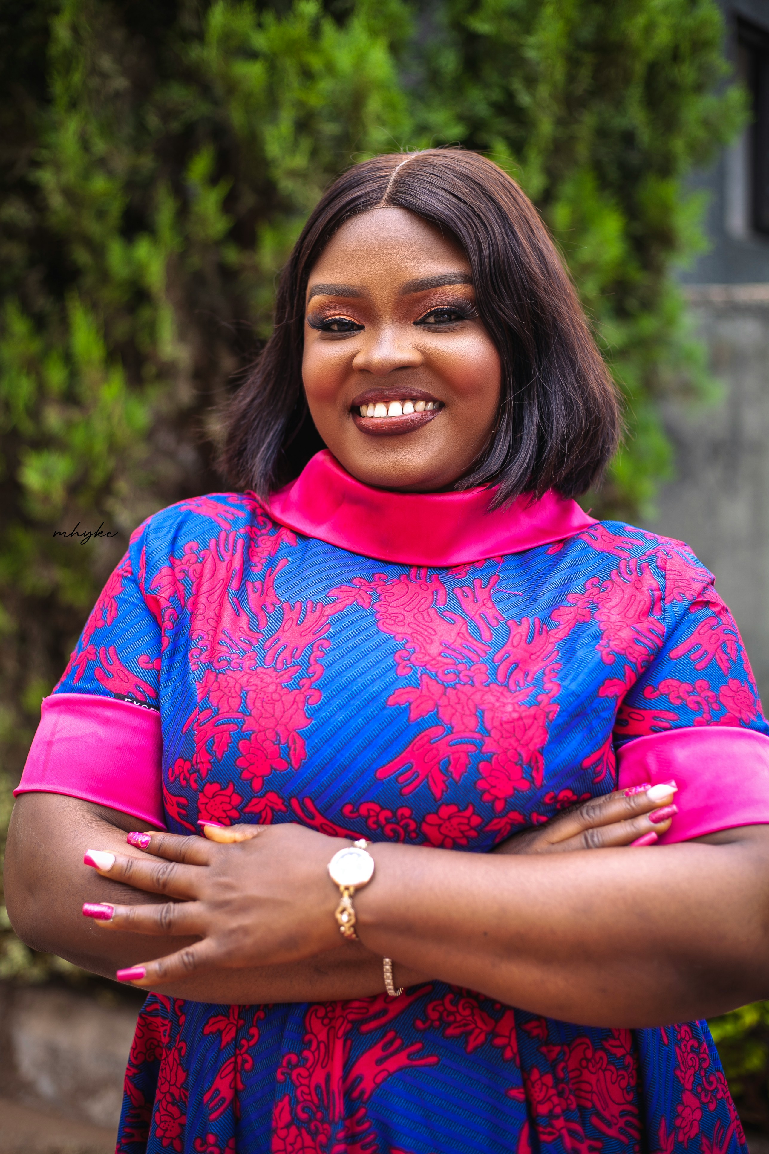 Woman smiles warmly while crossing her arms.