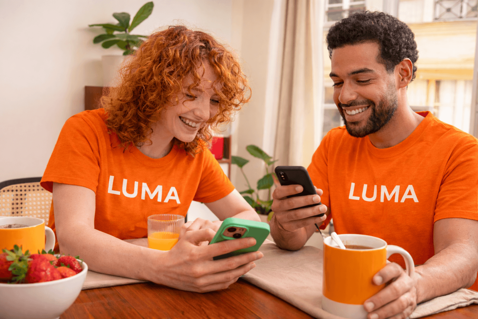woman holding a phone and man looking at the phone. both are smiling