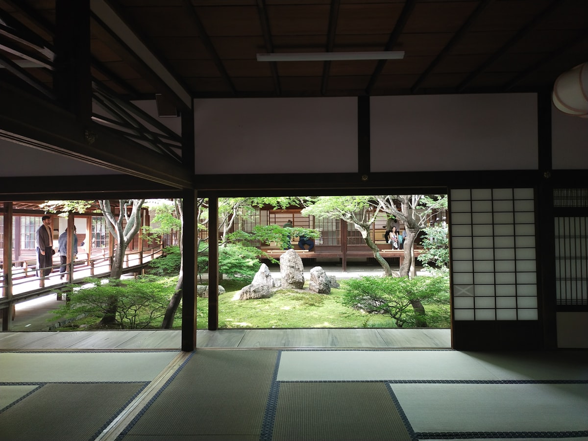 Traditional Japanese ryokan room with tatami floor overlooking a serene garden, a key japan travel budget choice