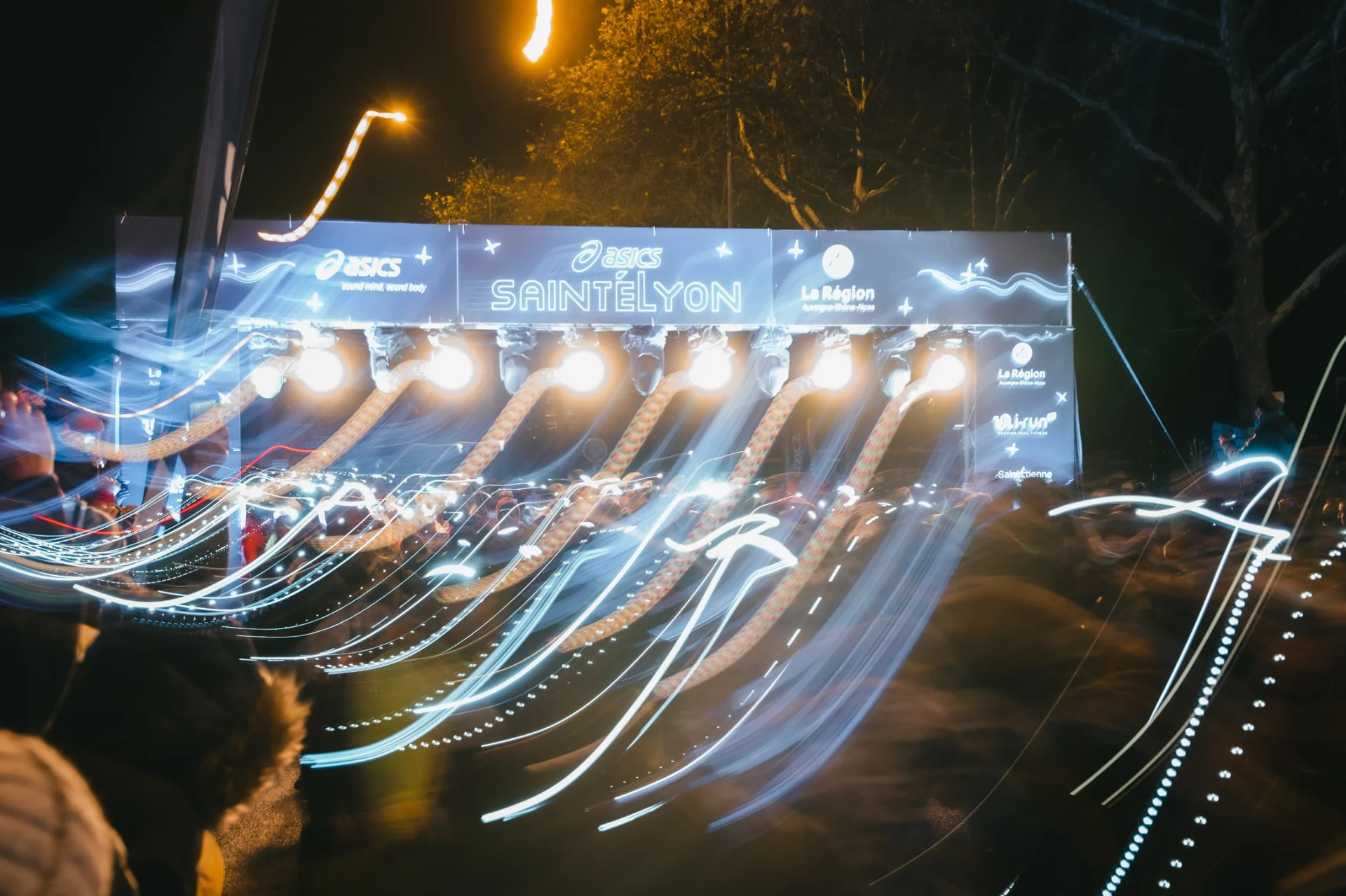 Light trails from runners' headlamps at the SaintéLyon start line - long exposure captured by Outdoor Perspectives