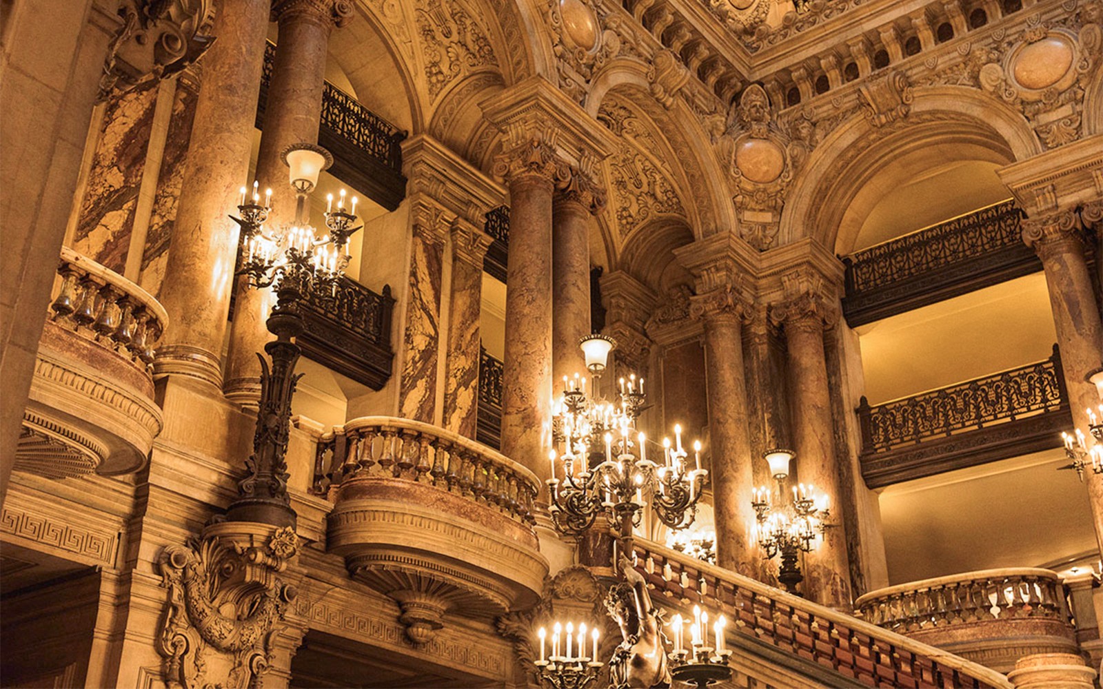 Cầu thang lớn của Nhà hát Garnier Opera với đèn chùm trang trí công phu tại Paris, được giới thiệu trong trò chơi tương tác Arsene Lupin.