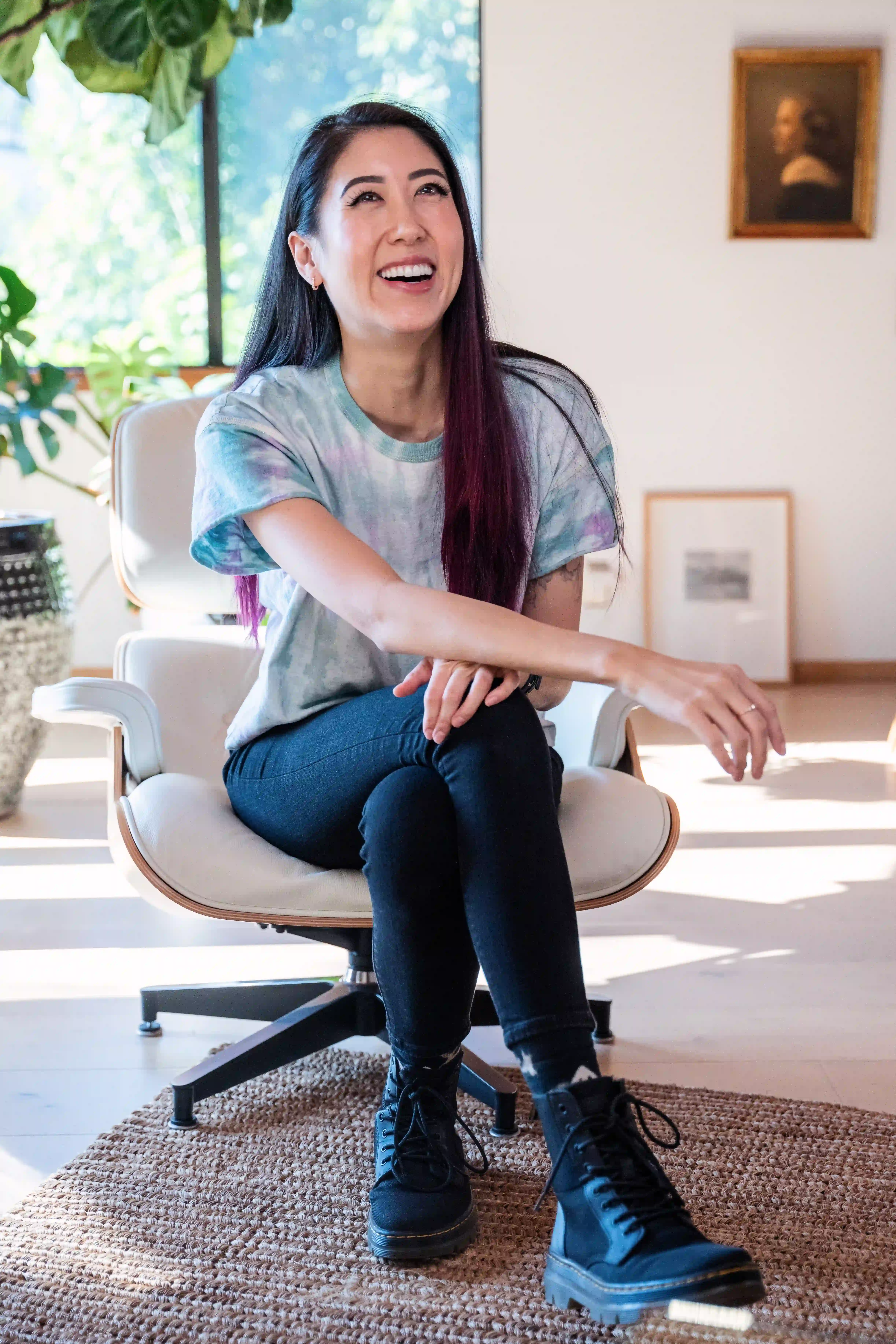 bisexual affirming therapist sitting in a chair smiling warmly while discussing the identity-affirming, trauma-informed care that expansive therapy offers.