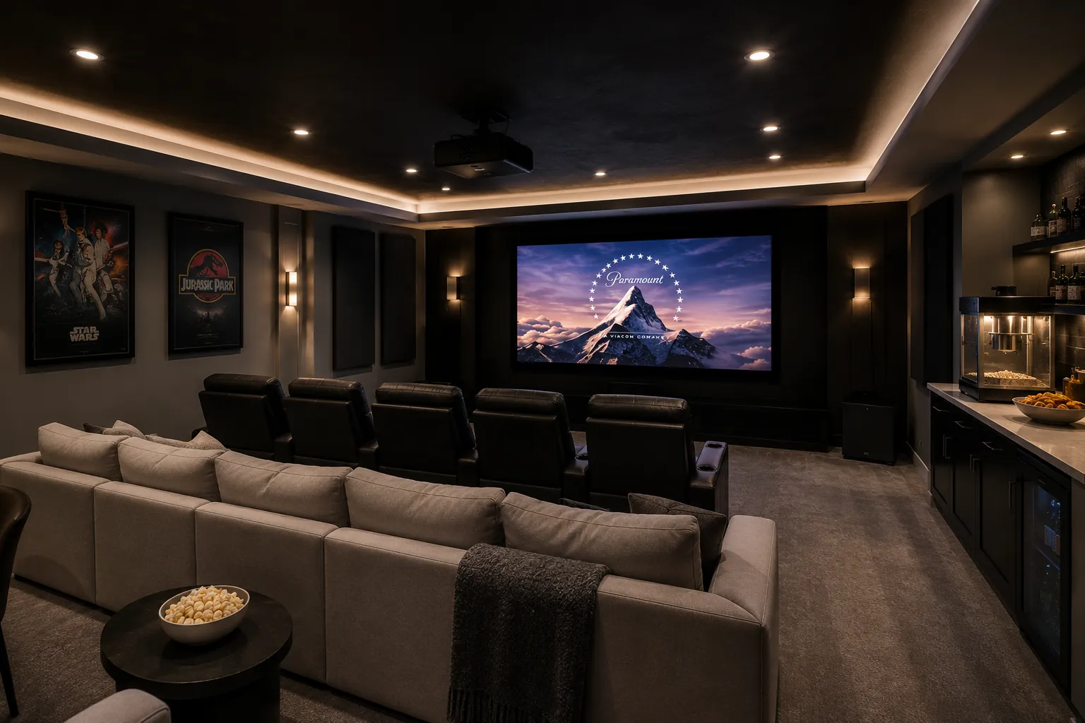 Upscale home theater basement with tiered seating, projection screen, movie posters, front-row cream sectional, popcorn concession counter with snack bar, and premium cinema experience.